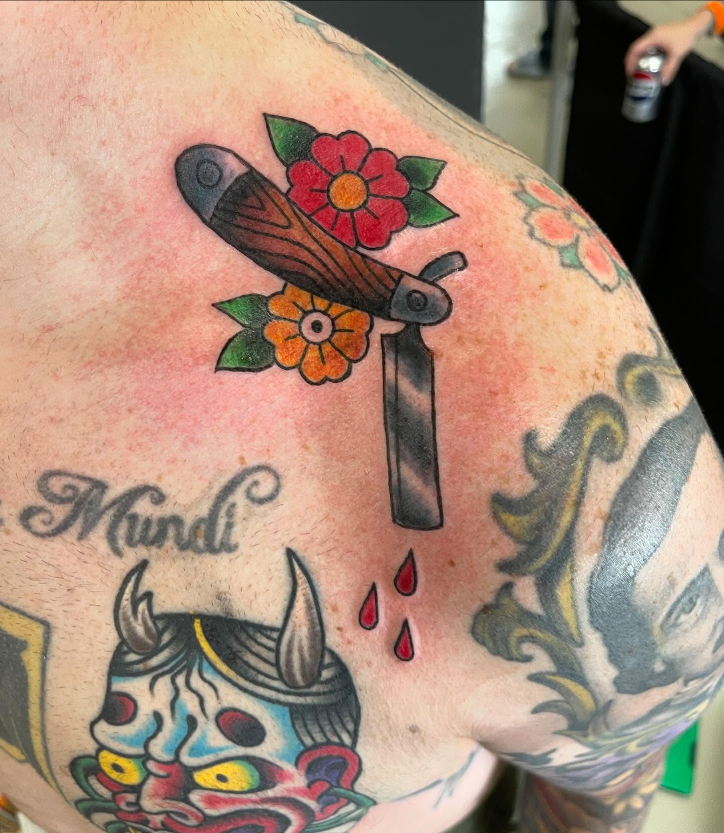 Knife and flowers American traditional tattoo on the shoulder by Sue Garcia