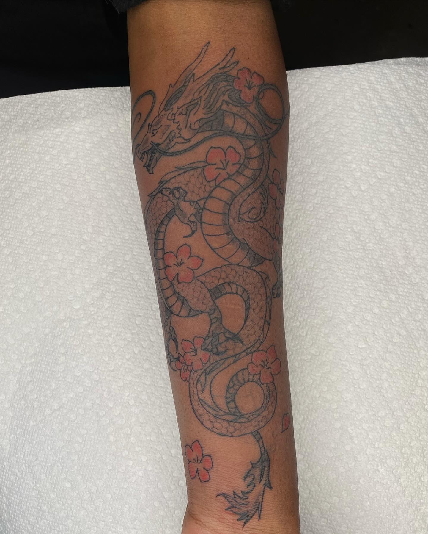 Dragon with flowers japanese irezumi tattoo on the forearm by Evan Chastain