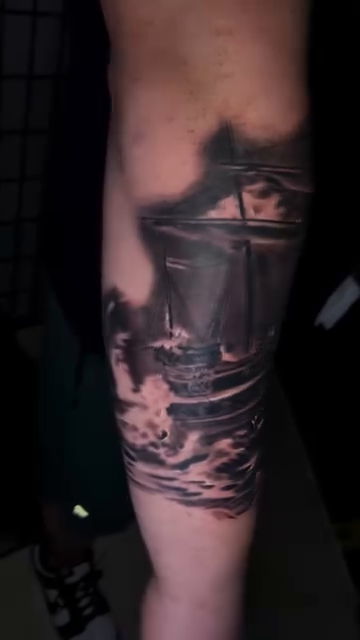 A ship in stormy seas realism tattoo by Sergio Ramirez