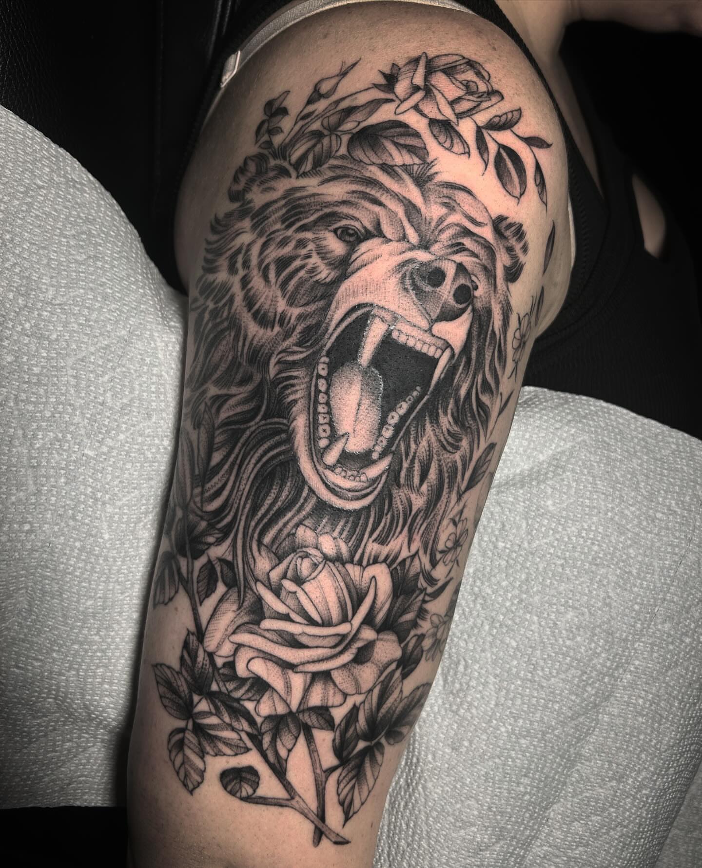 Roaring bear with roses realism tattoo on the forearm by Lena Lawrence