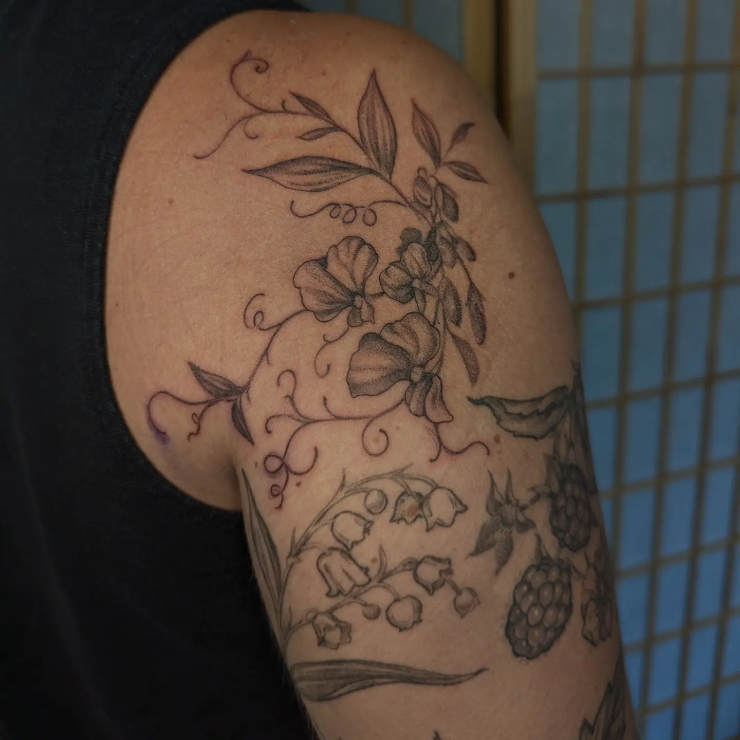 Floral arrangement black and grey tattoo on the shoulder by Jeanine, Providence, Rhode Island