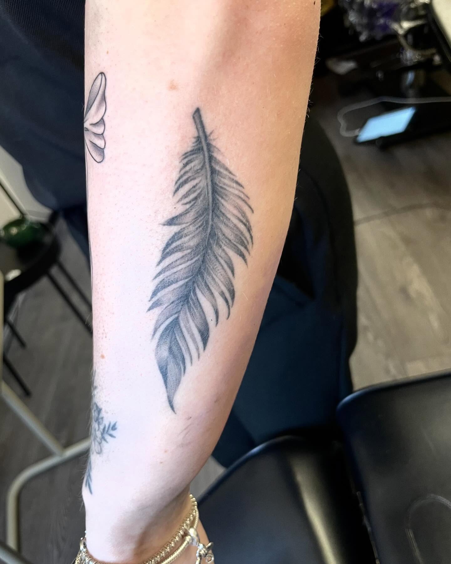 Feather black and grey tattoo on the forearm by Grace derby tattooist, Derby
