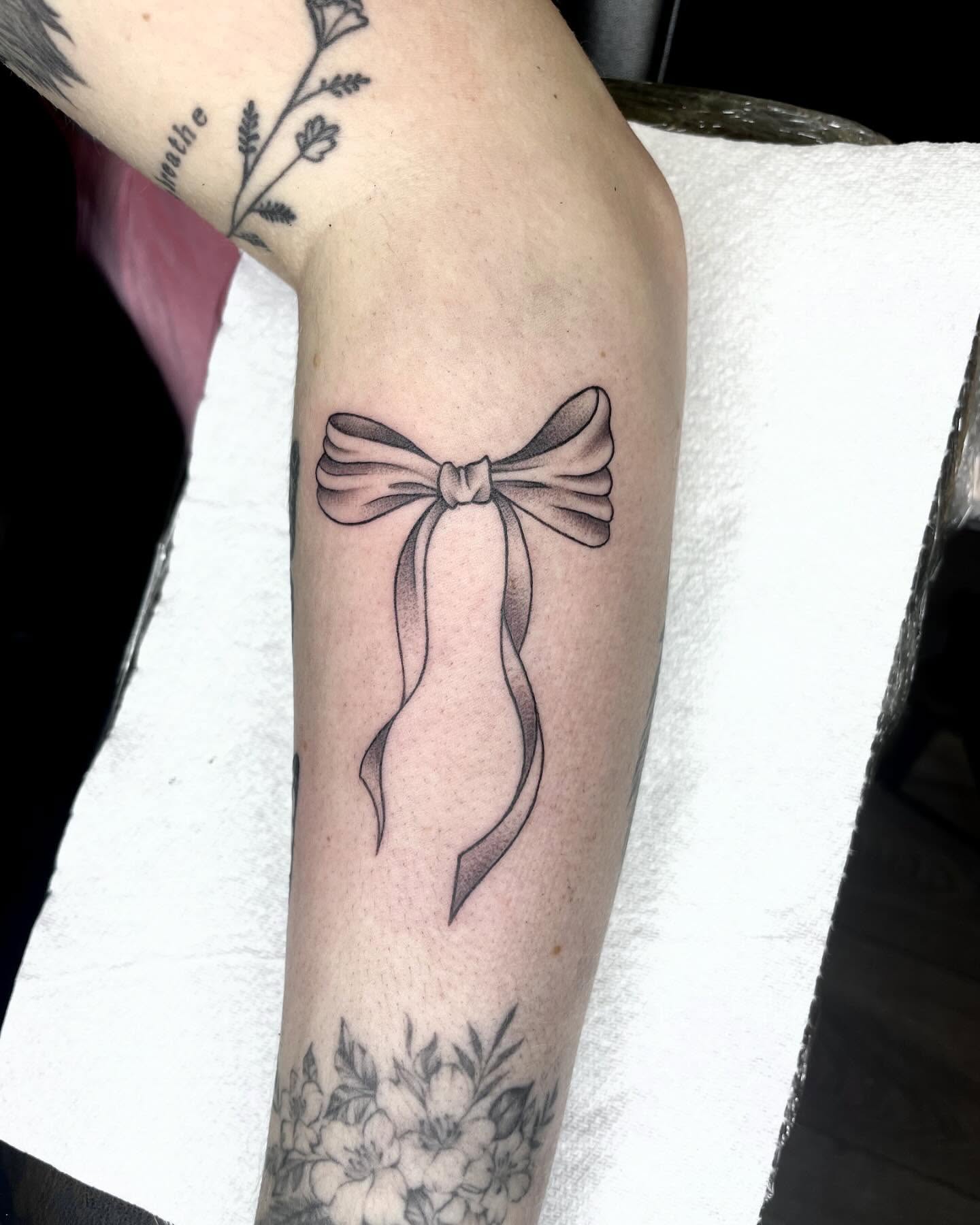 Bow black and grey tattoo on the forearm by Grace derby tattooist, Derby