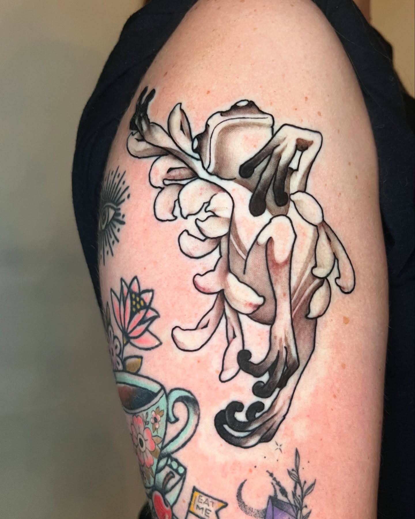 Flower frog American traditional tattoo on the upper arm by Joshua Weeks