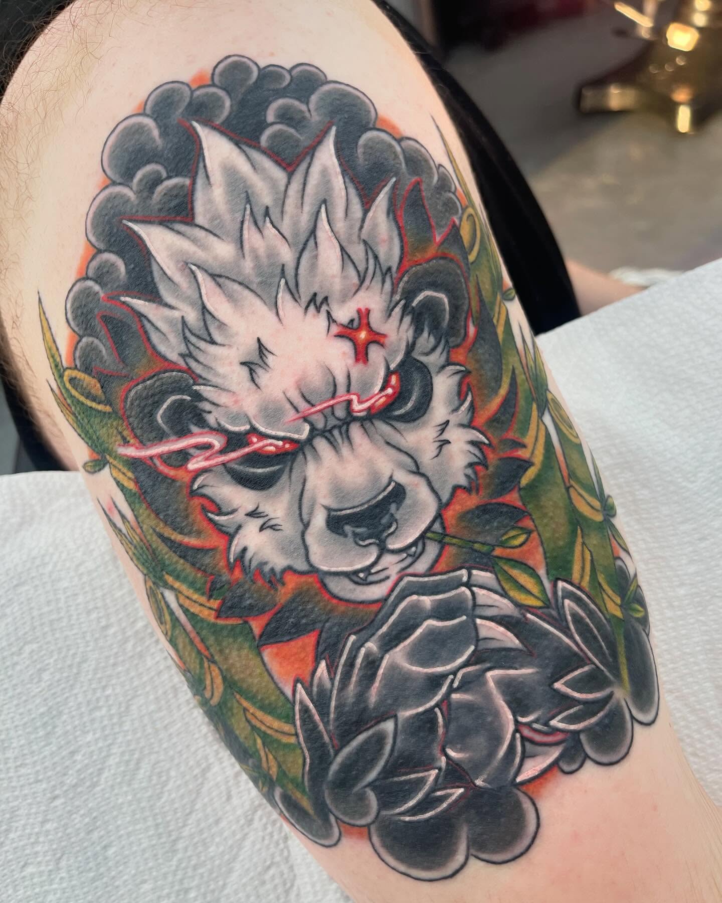 Wolf American traditional tattoo on the upper arm by Autumn Fulford