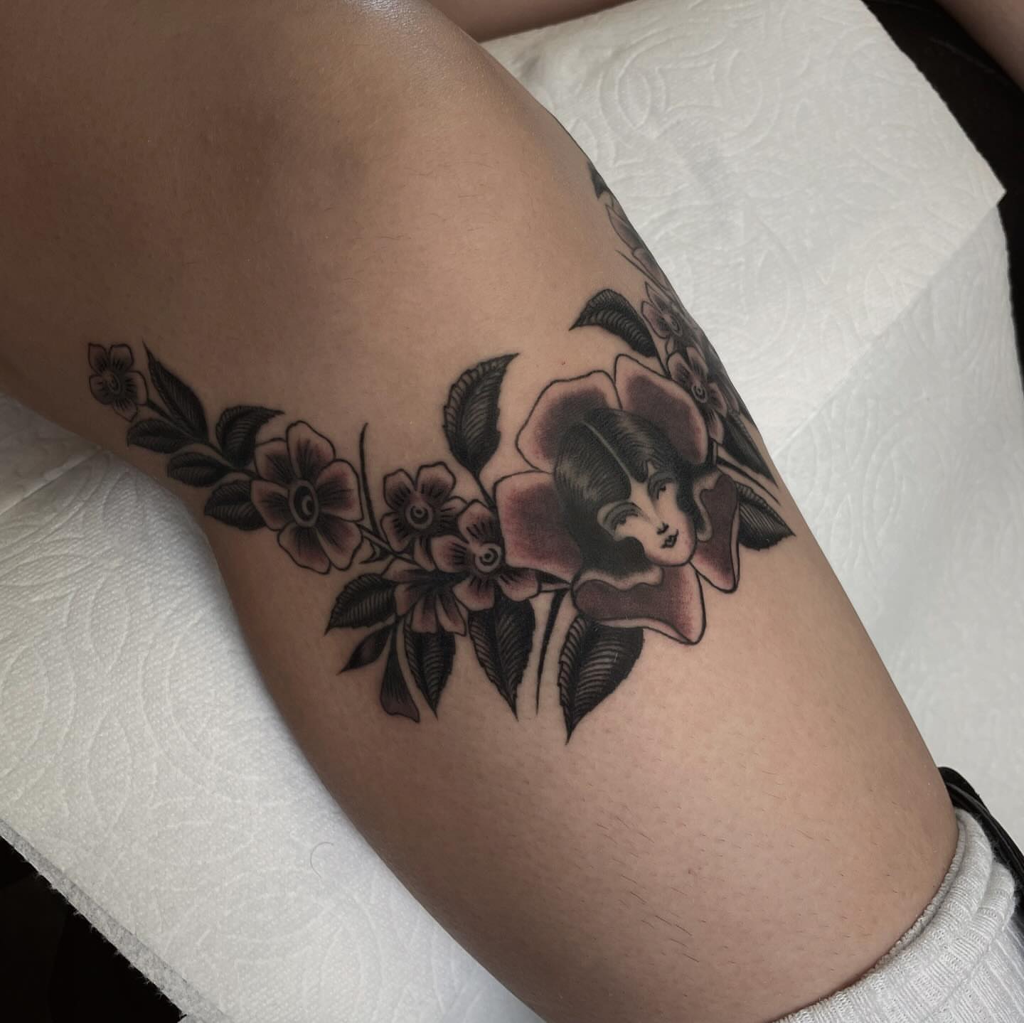 Flower and woman American traditional tattoo on the forearm by Niko Mulhearn