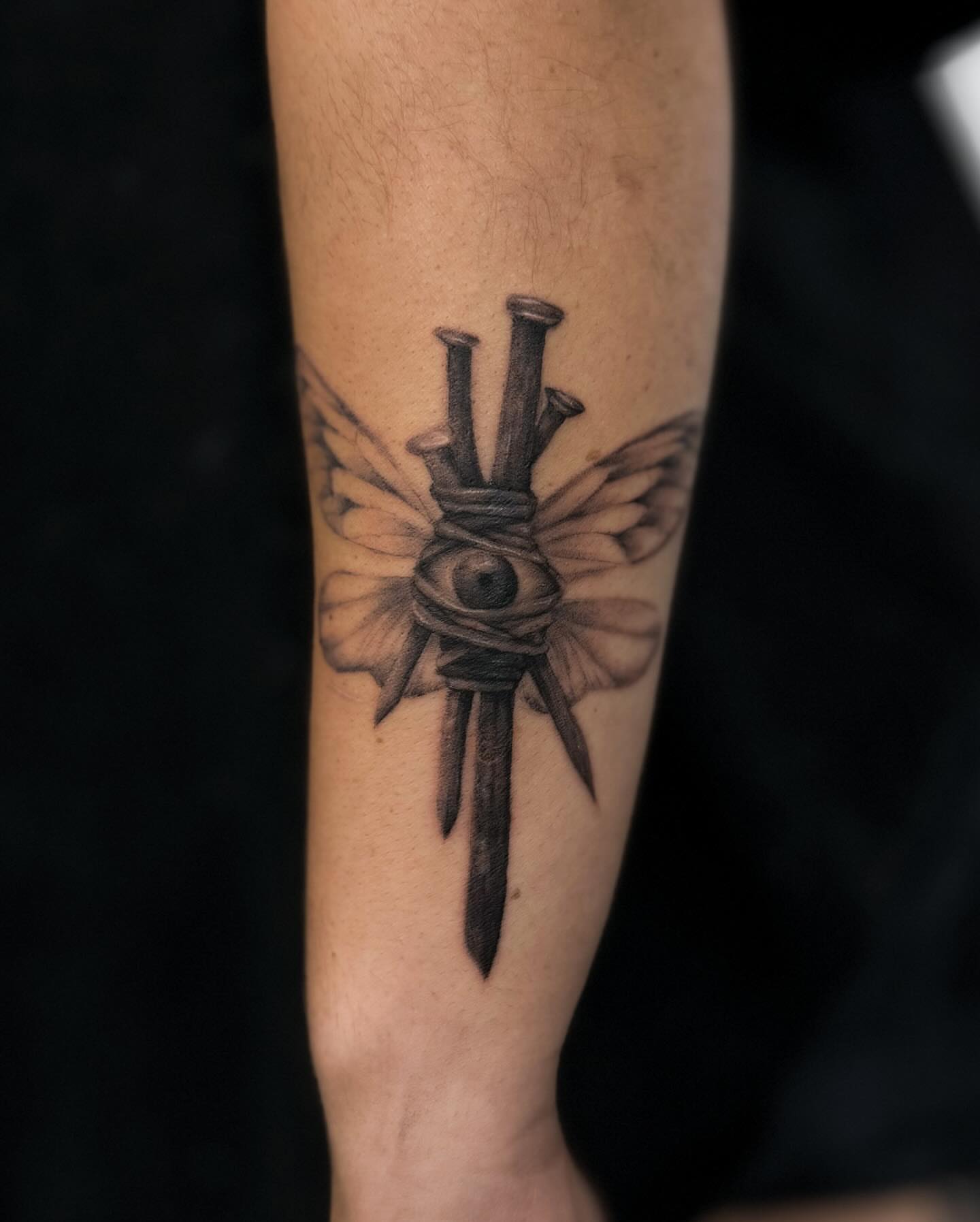 Nail and eye black and grey tattoo on the forearm by Rose