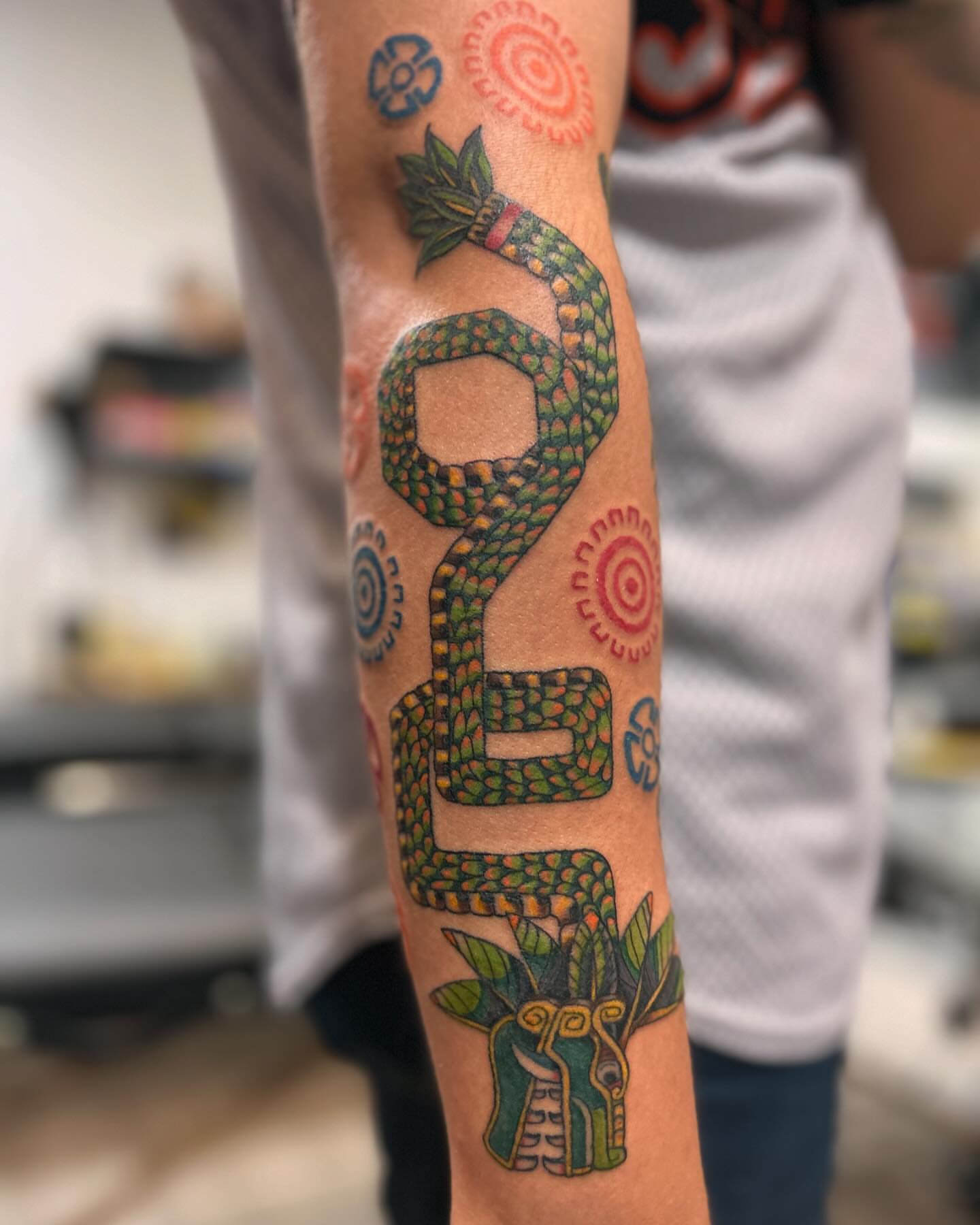 Serpent and mask geometric tattoo on the forearm by 🇬🇹
