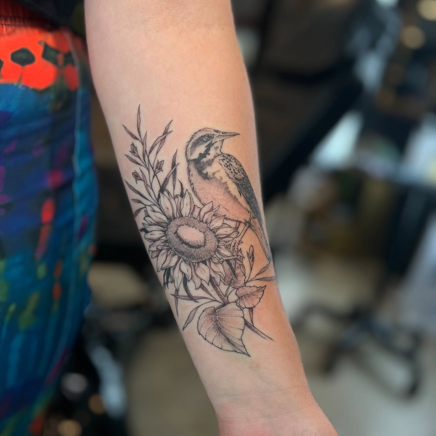 Bird and sunflower black and grey tattoo on the forearm by Dom