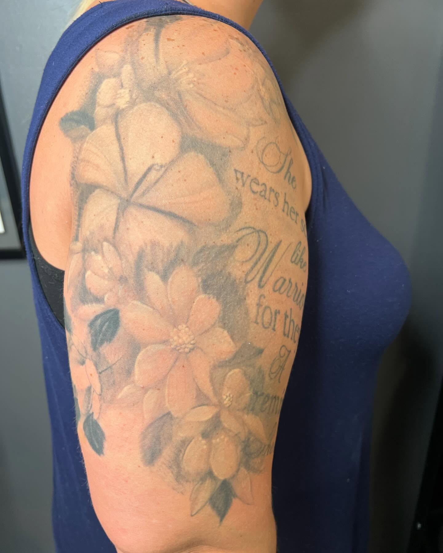 Floral arrangement black and grey tattoo on the upper arm by Taylor Steckman