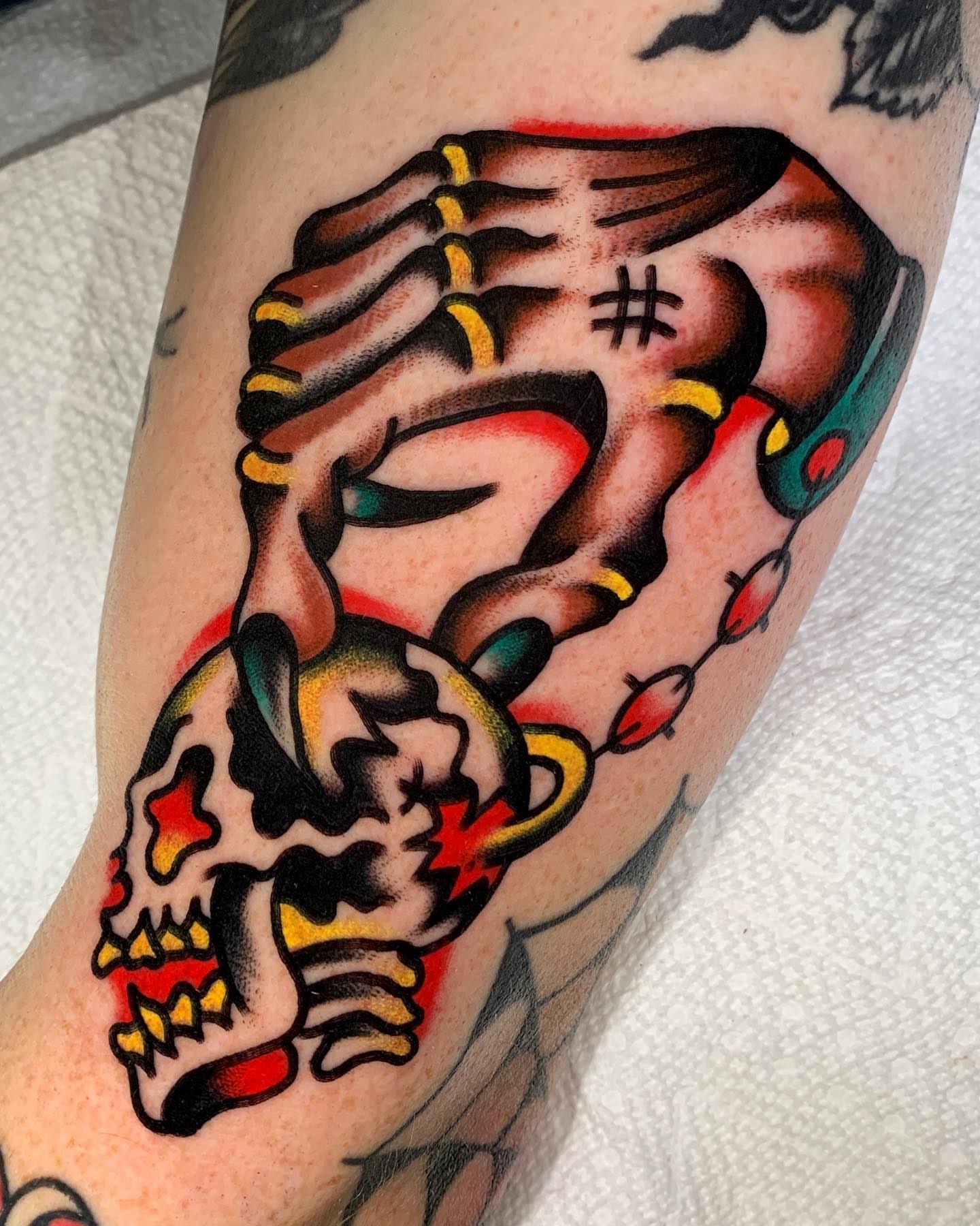 Skull and hand American traditional tattoo on the forearm by Zachary - Traditional Tattoo Artist