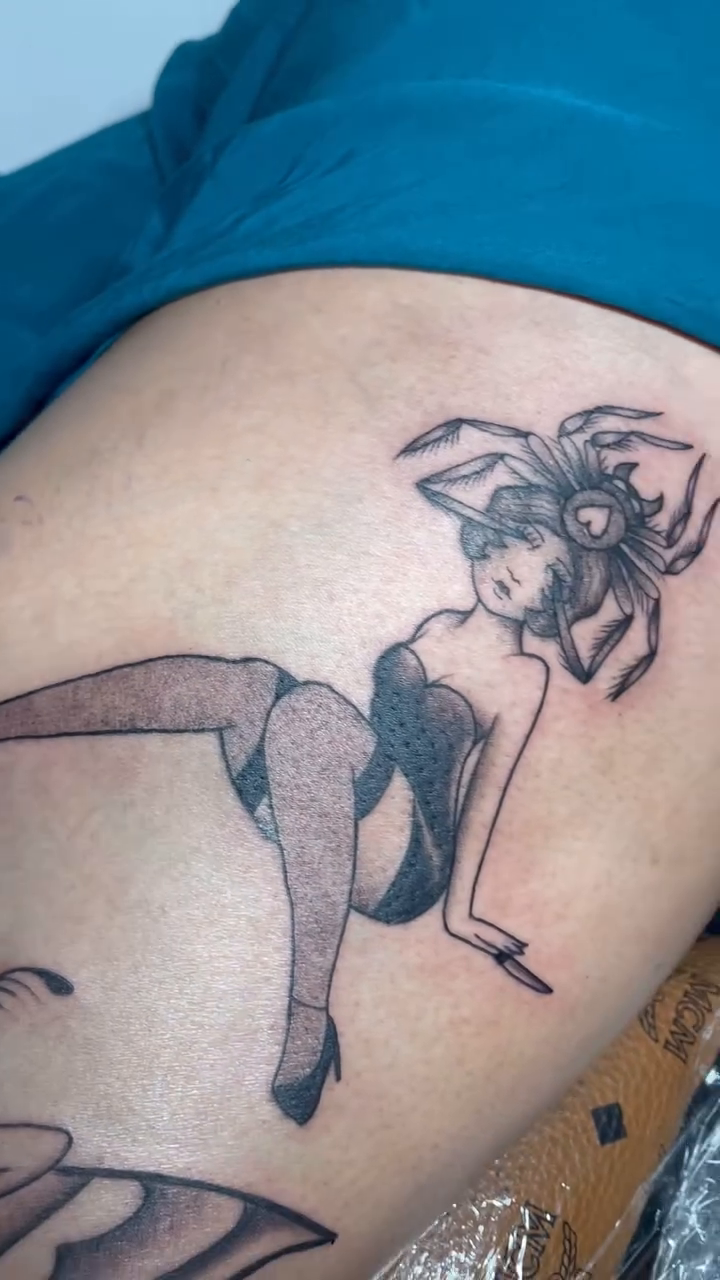 Pin-up girl with spider elements realism tattoo on the thigh by Natalie