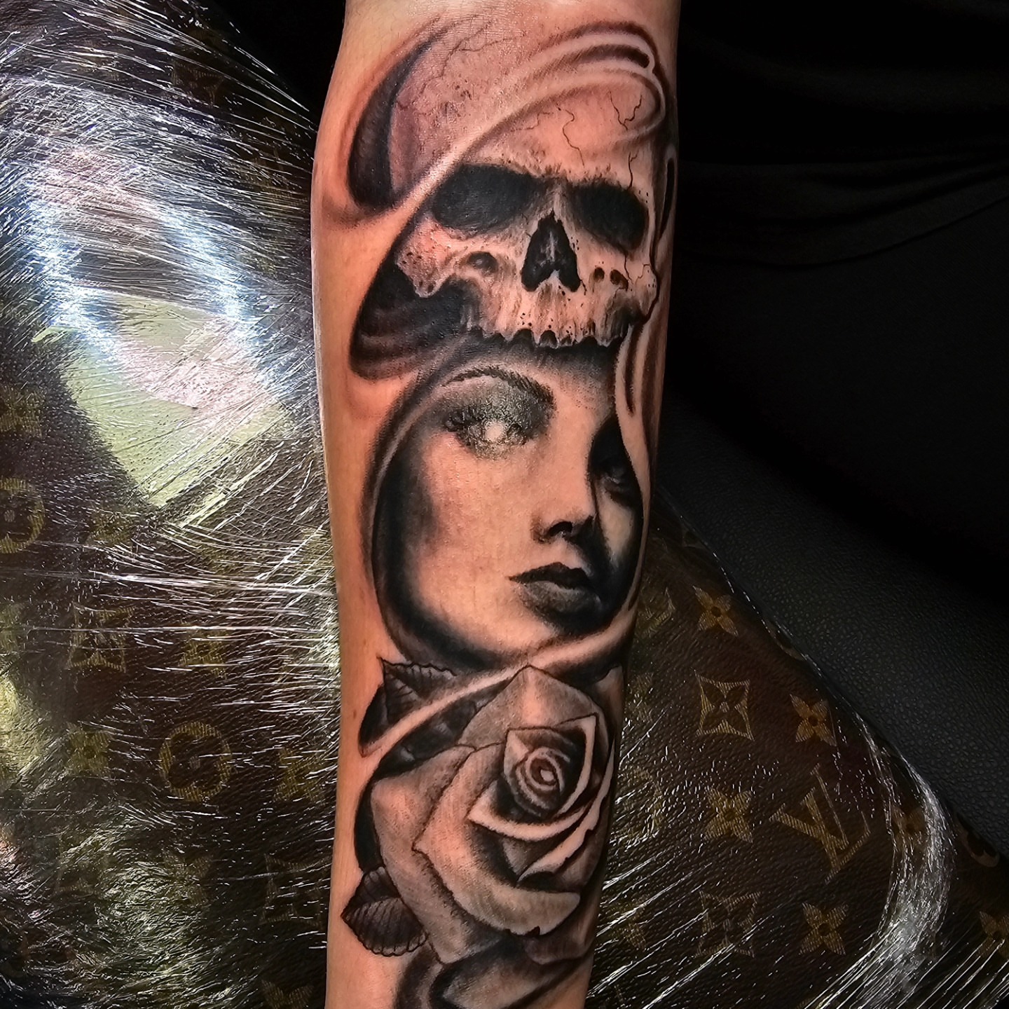 Woman with skull and rose realism tattoo on the forearm by Germaine Sherman