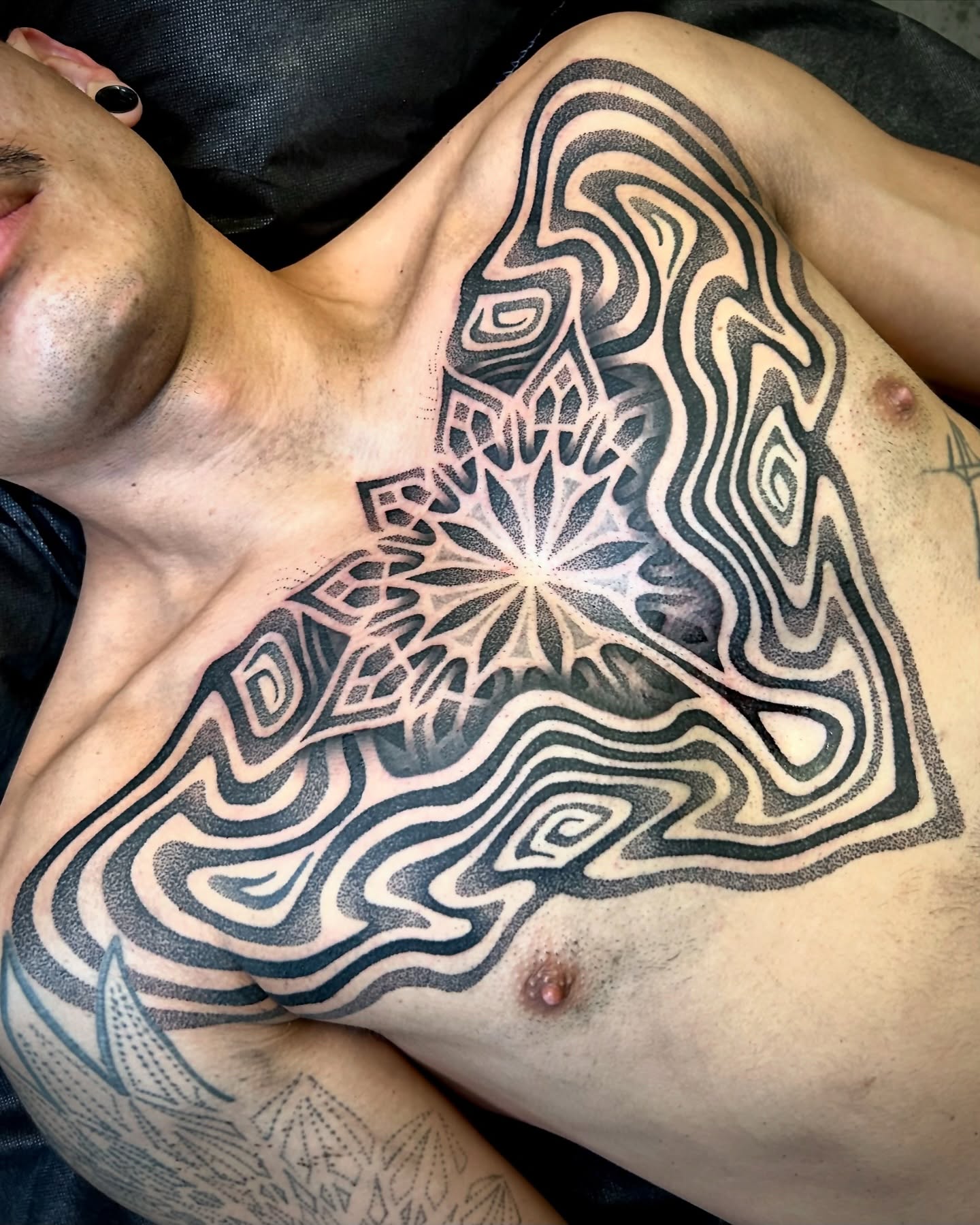Geometric mandala dotwork tattoo on the chest by Ross Krandel