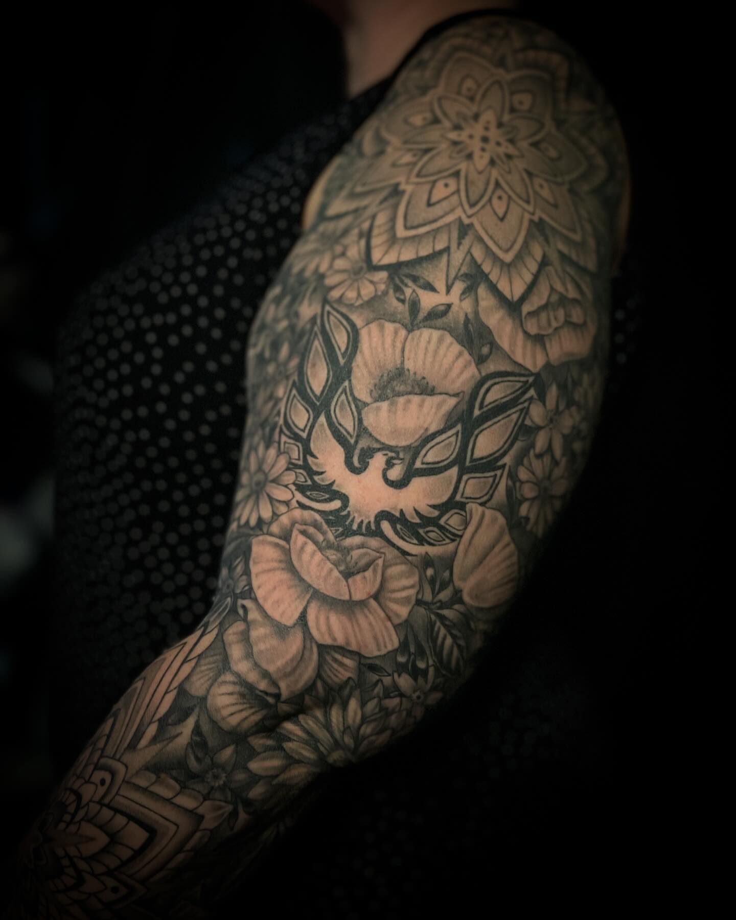 Floral and bird geometric tattoo on the upper arm by Jacob Finelli