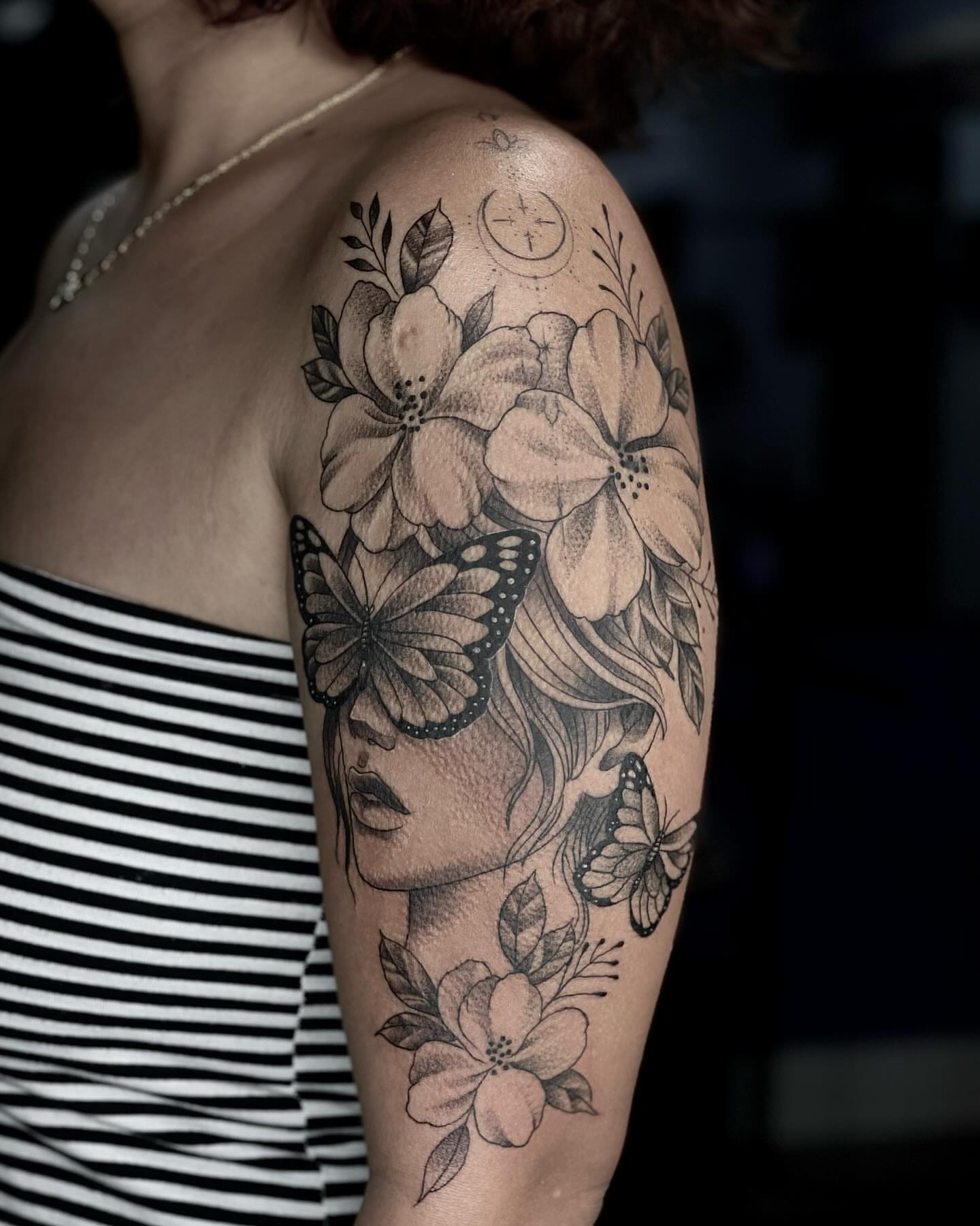 Woman with flowers and butterflies dotwork tattoo on the upper arm by Tam Nguyen