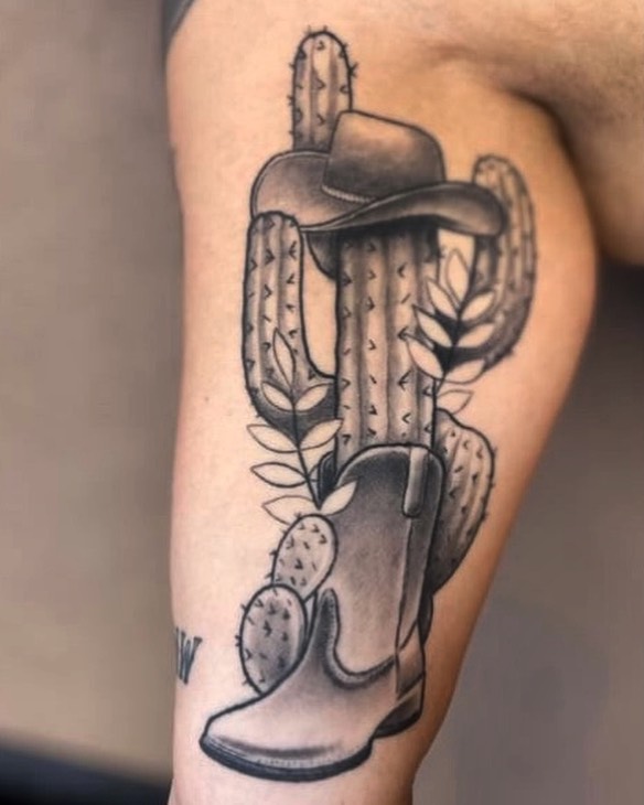 Cowboy boot and cactus black and grey tattoo on the forearm by Sean Cavanaugh