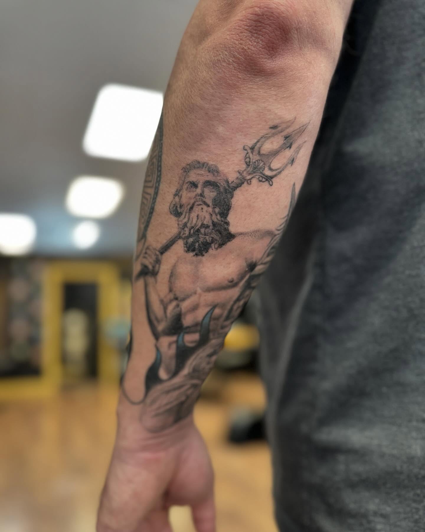 Poseidon black and grey tattoo on the forearm by Kyle J. Bishop