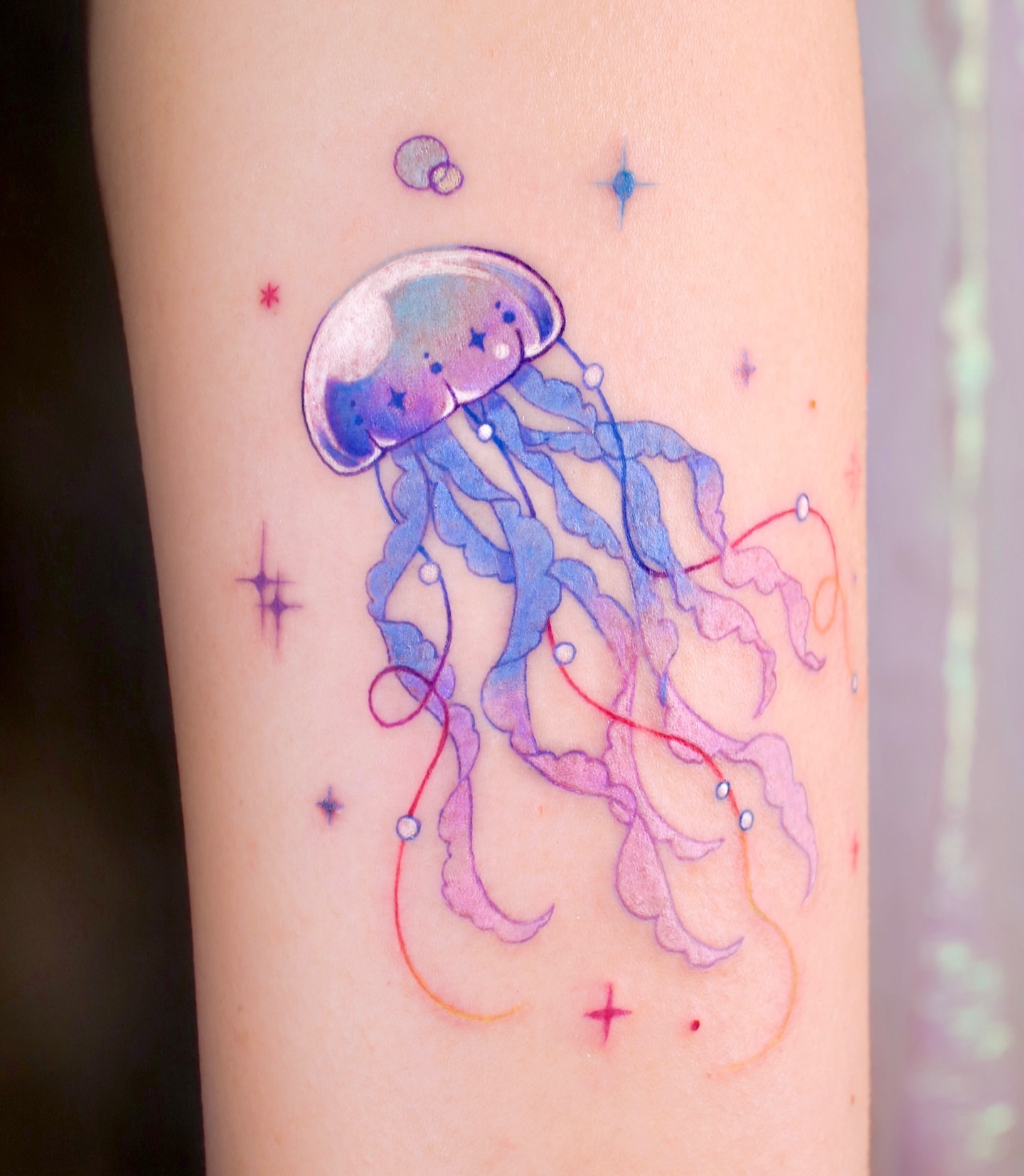 Jellyfish watercolor tattoo on the forearm by 밍꽈 타투