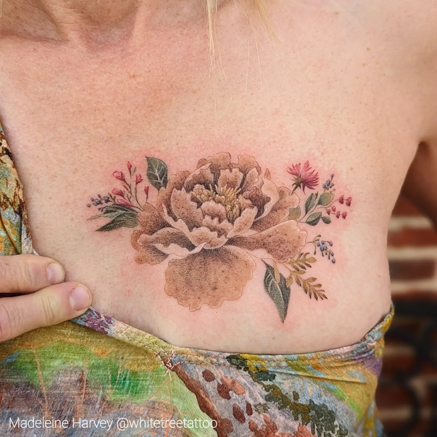 Peony flower watercolor tattoo on the chest by Maddie