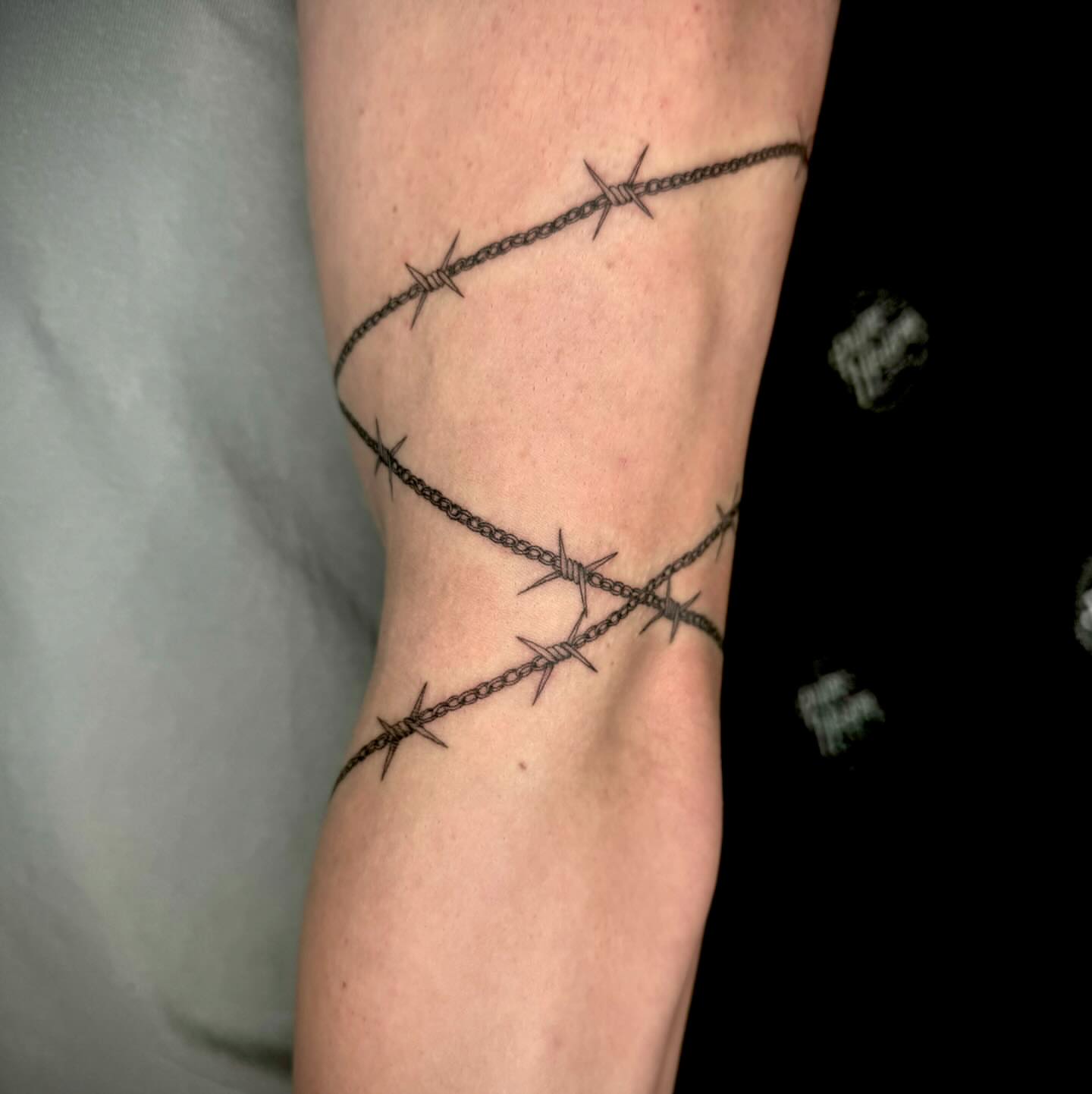 Barbed wire black and grey tattoo on the forearm by oh hey, robin.