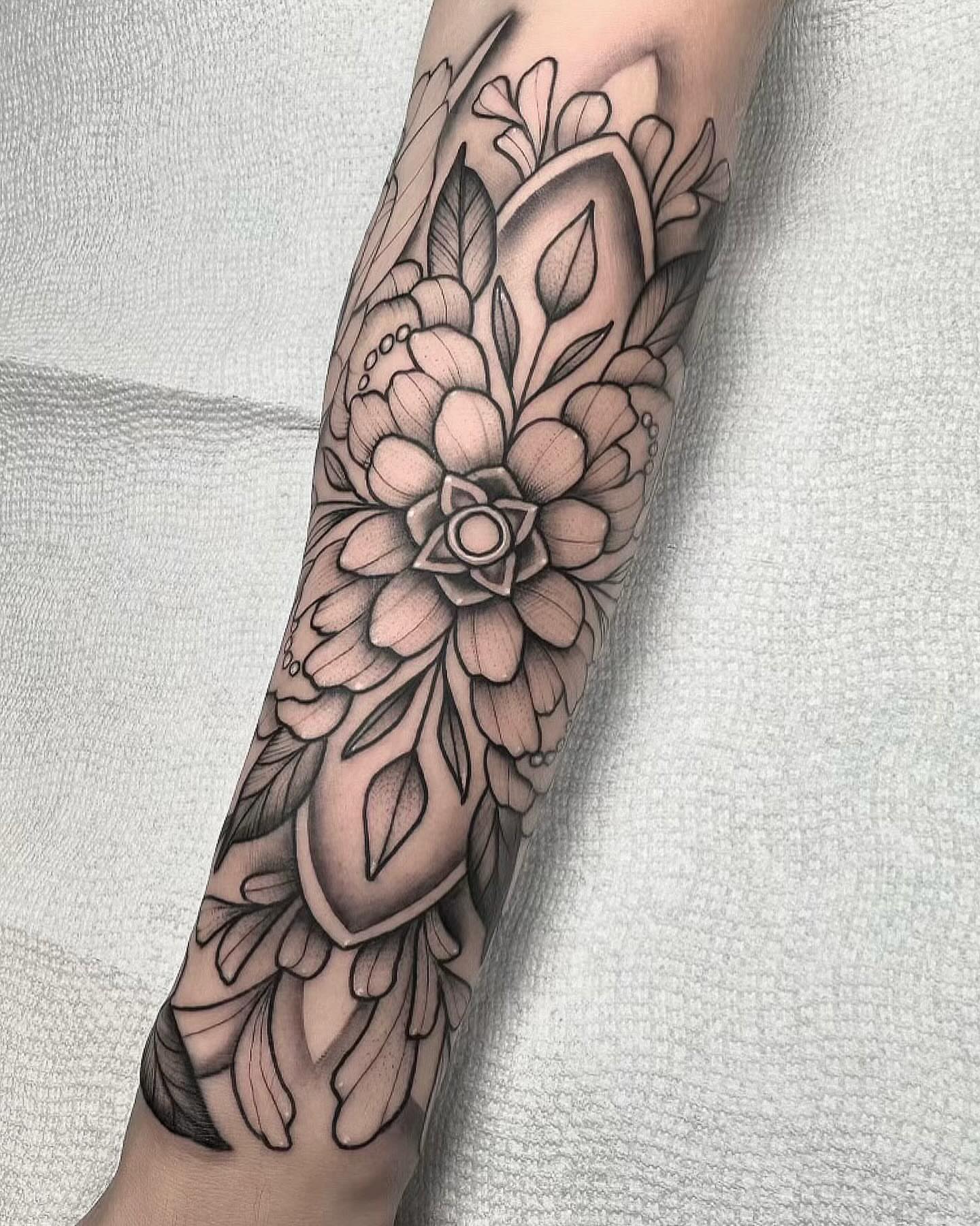 Floral bouquet black and grey tattoo on the forearm by Lawrence Edwards