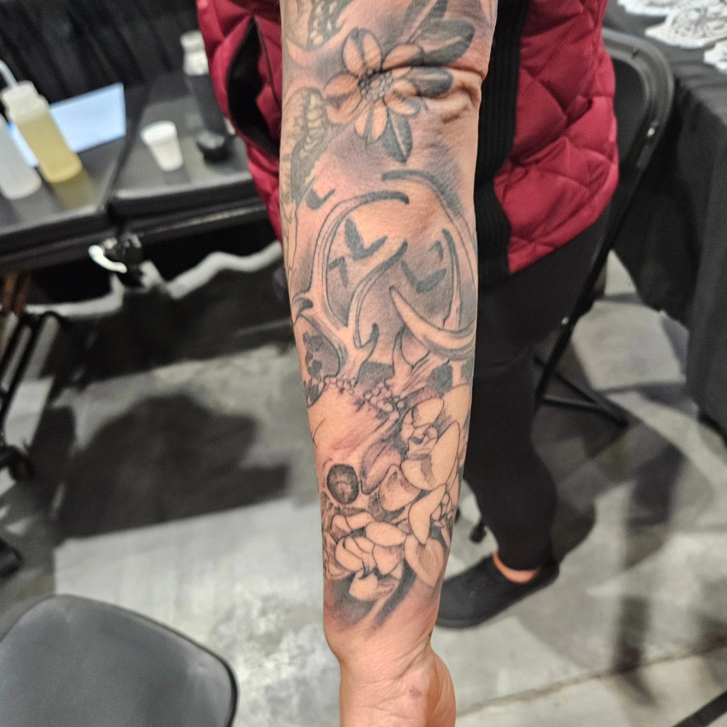 Floral and abstract design black and grey tattoo on the forearm by German Romero-Rendon