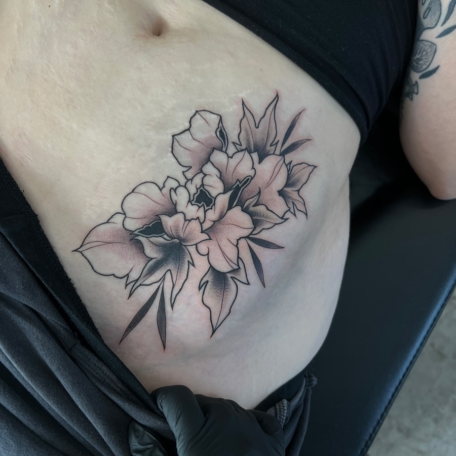 Peony bouquet black and grey tattoo on the ribs by Dom