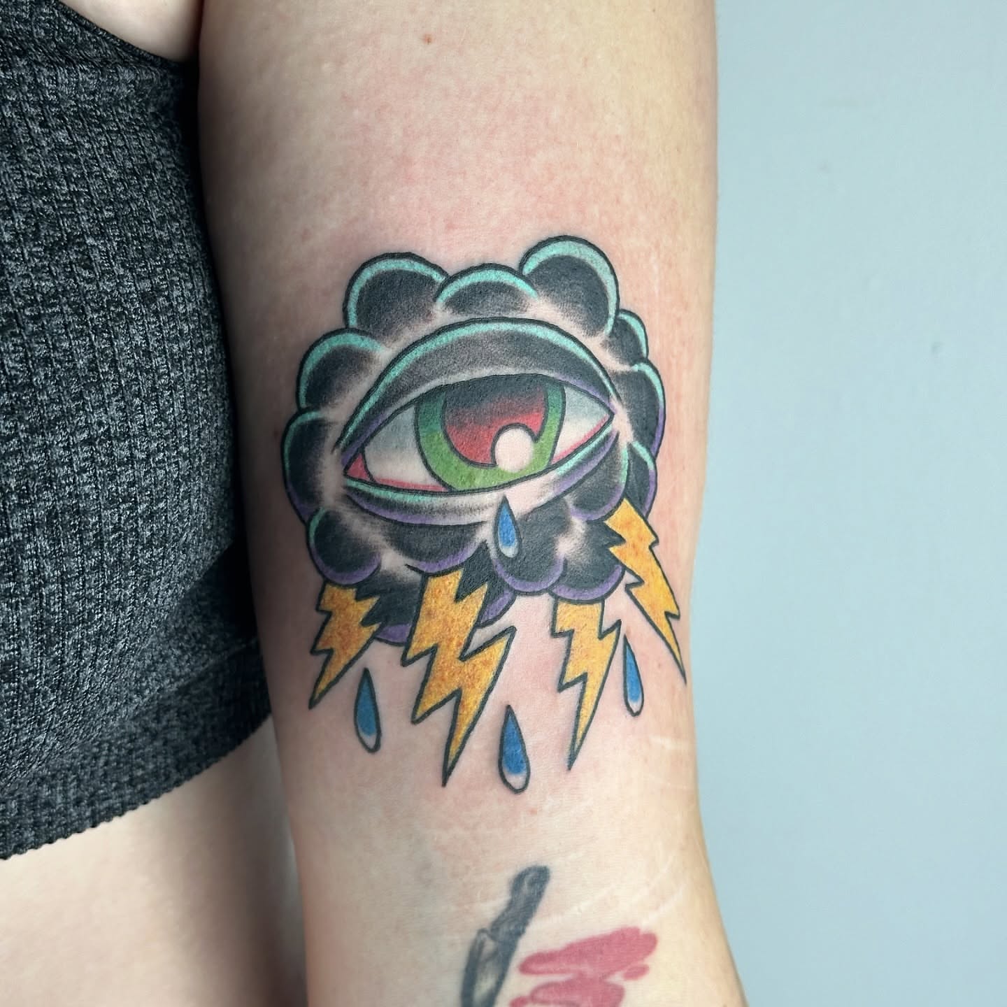 Eye with lightning bolts American traditional tattoo on the forearm by Sarah Bobby, Houston, Texas