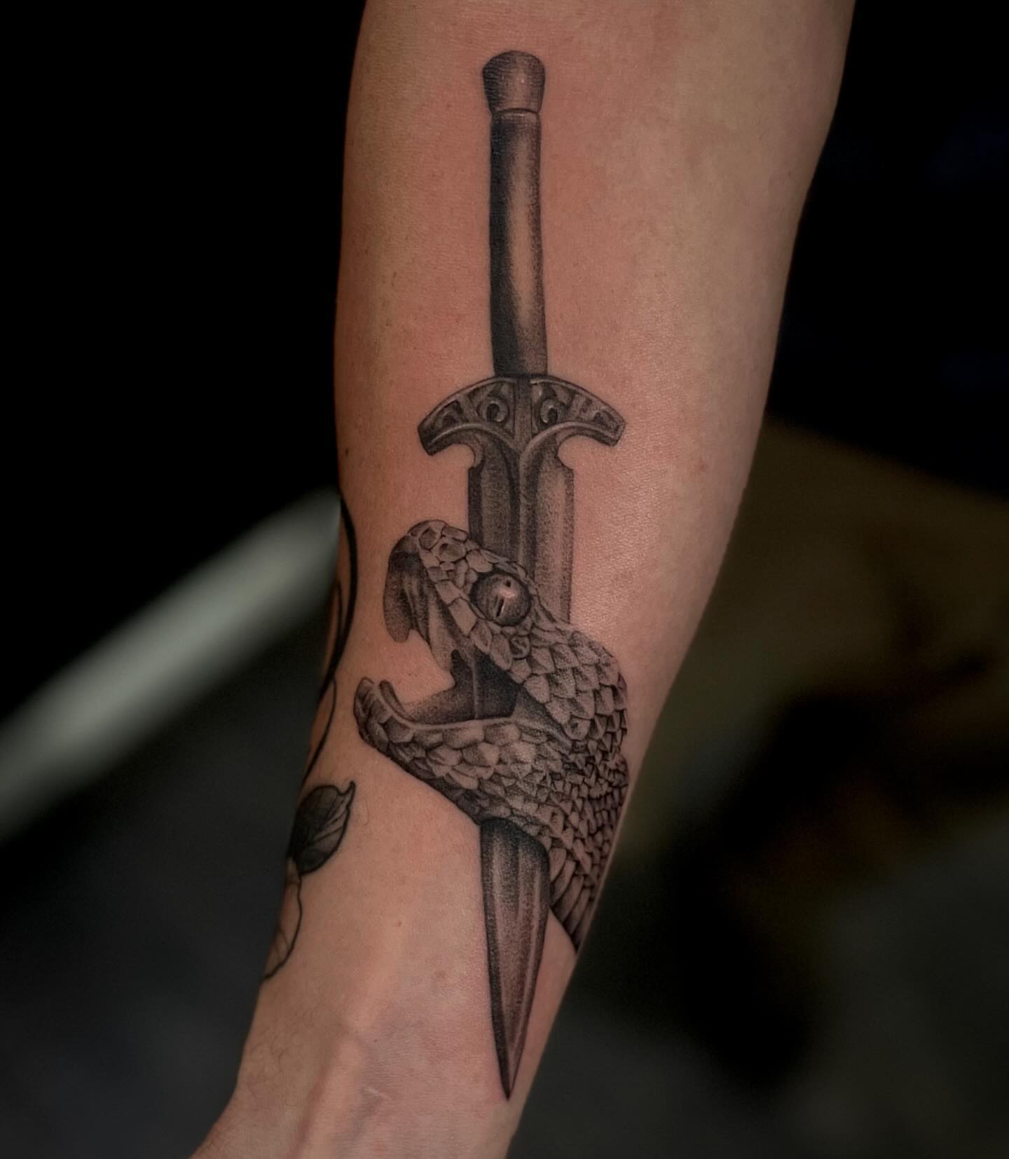 Sword and snake black and grey tattoo on the forearm by Lee Ranco