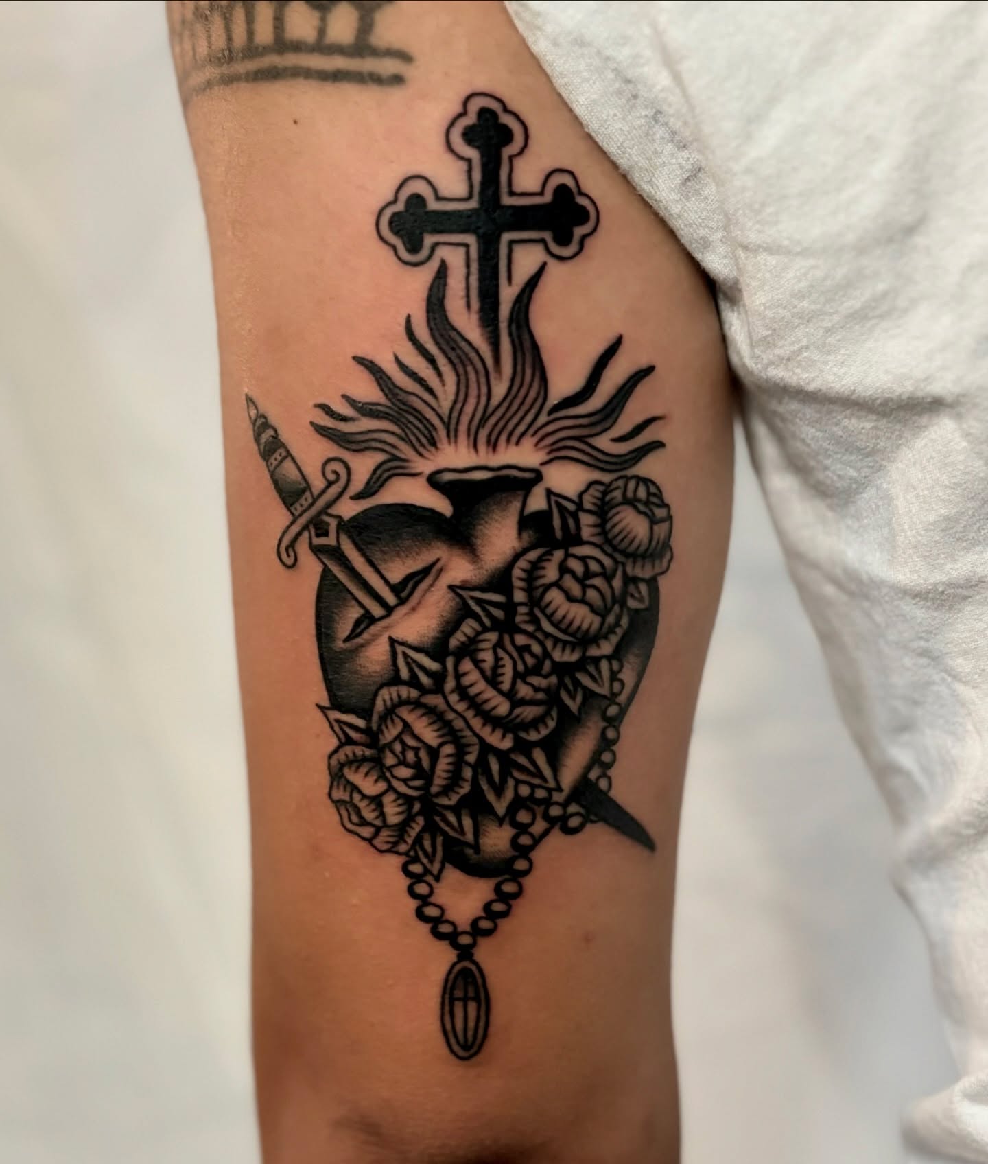 Heart with cross and roses American traditional tattoo on the forearm by Weston Imhoff
