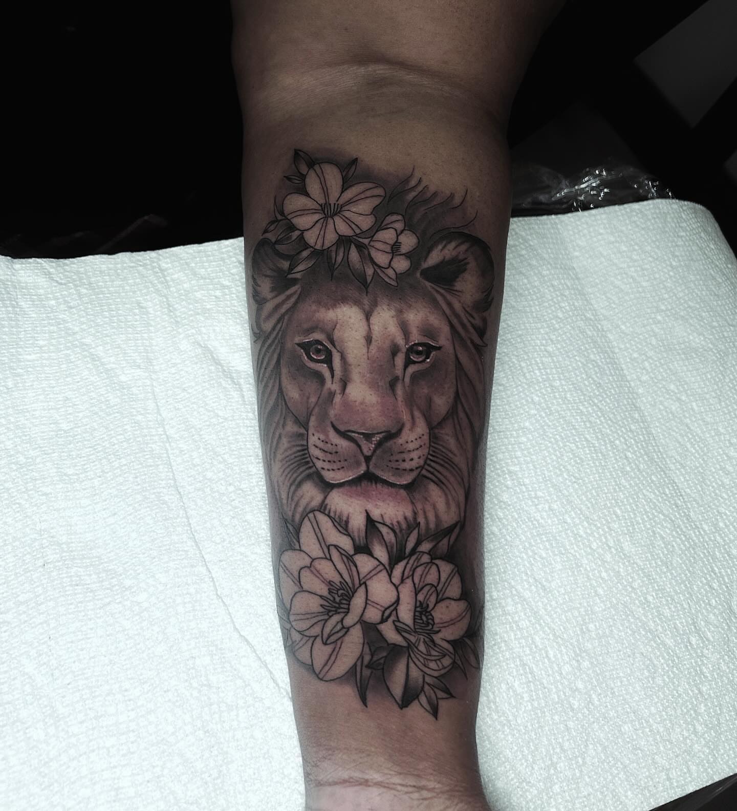 Lion with flowers realism tattoo on the forearm by Shake_tatts