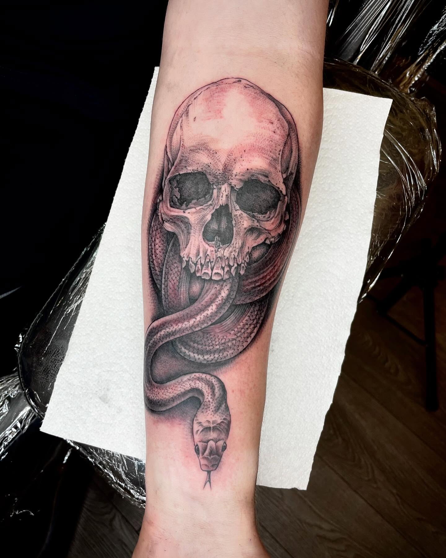 Skull and snake realism tattoo on the forearm by Grace derby tattooist, Derby