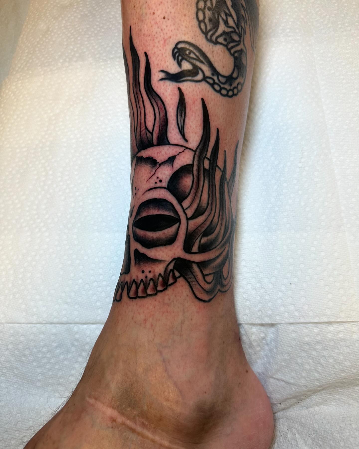 Flaming skull black and grey tattoo on the calf by Noah Diffenderfer, Phoenix, Arizona
