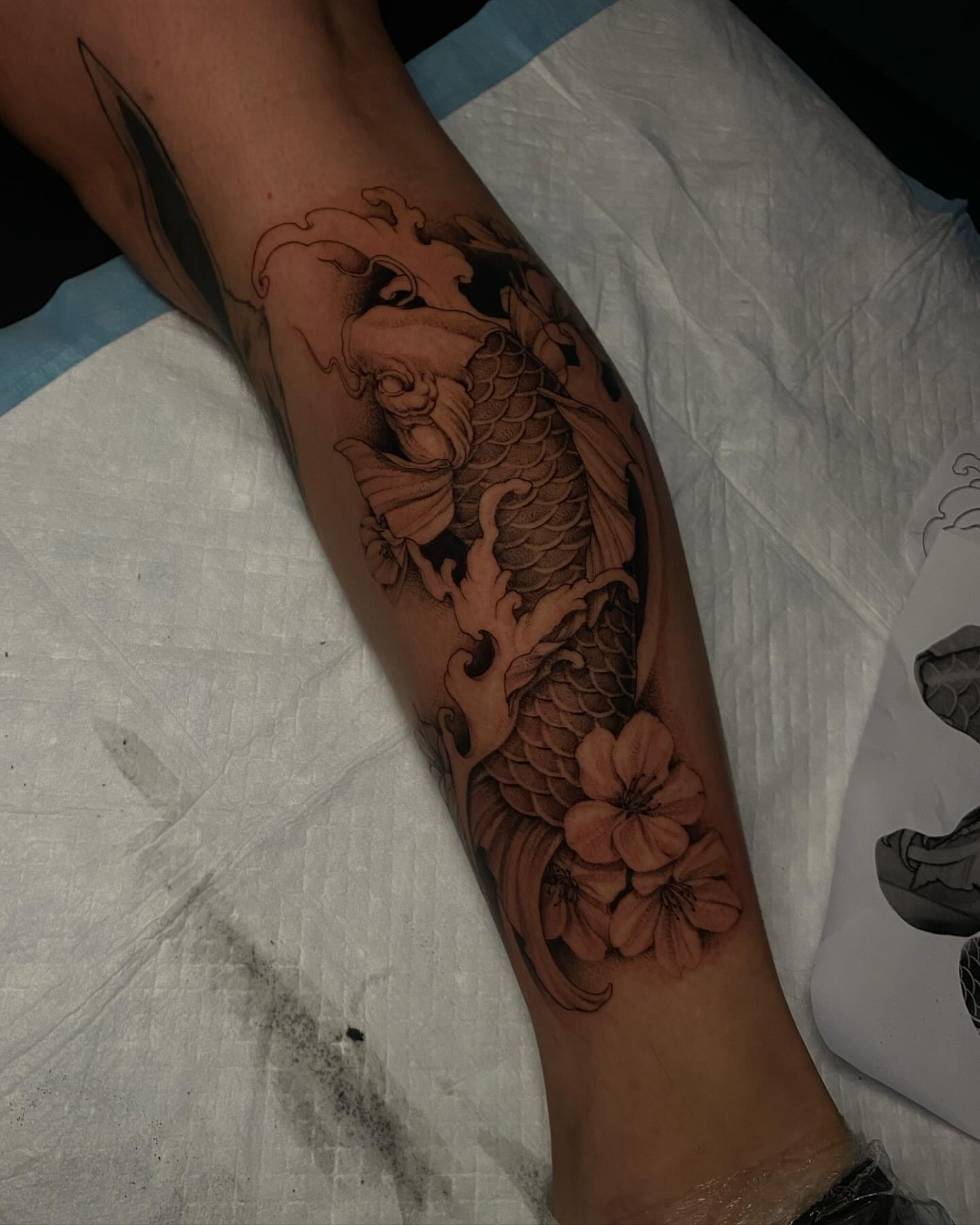 Koi fish and cherry blossoms realism tattoo on the forearm by Sydney Dixon, Sacramento, California