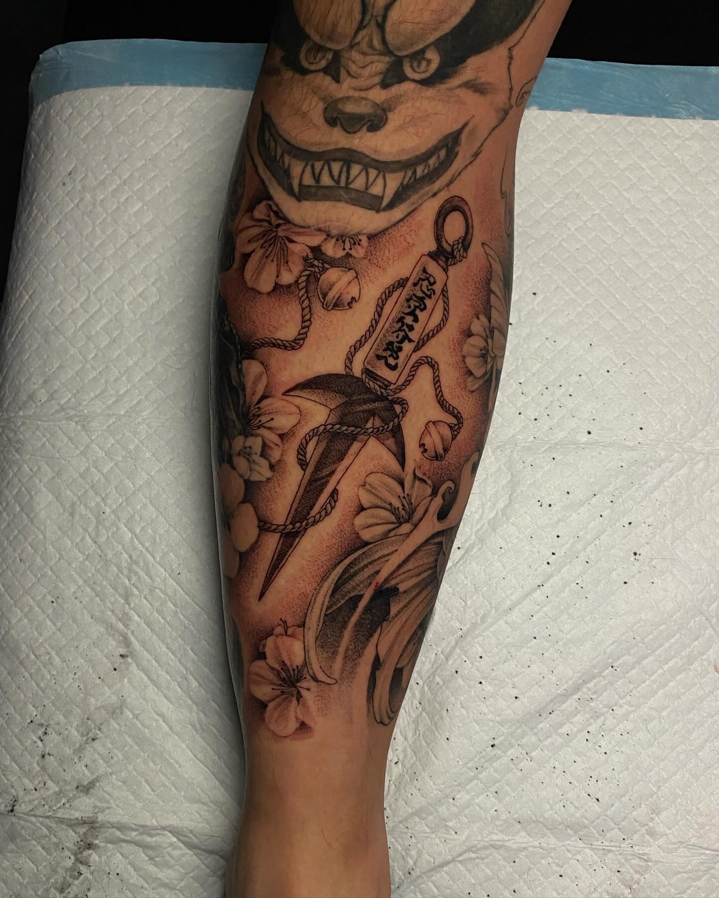 Demon mask with flowers realism tattoo on the forearm by Sydney Dixon, Sacramento, California