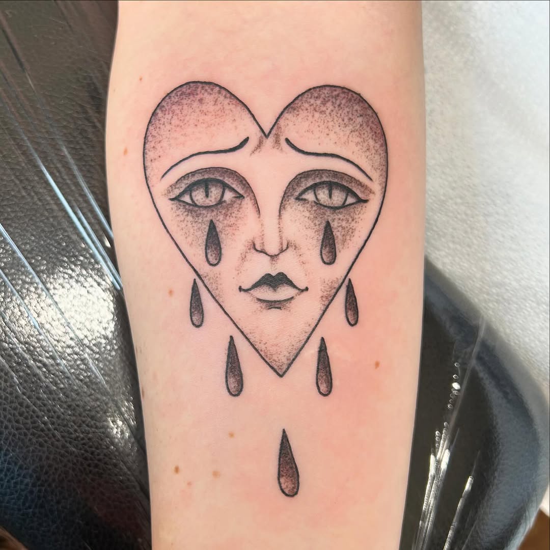 Crying heart face ignorant tattoo on the forearm by Jaime Gaiti