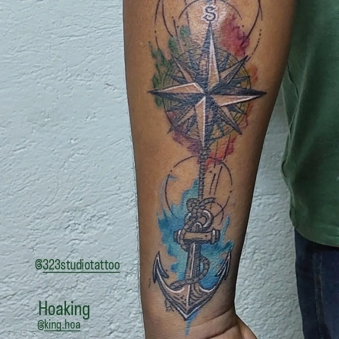 Compass and anchor watercolor tattoo on the forearm by Hoa King