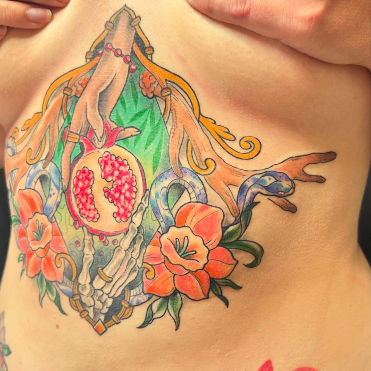 Pomegranate and hands American traditional tattoo on the chest by Halle Haas