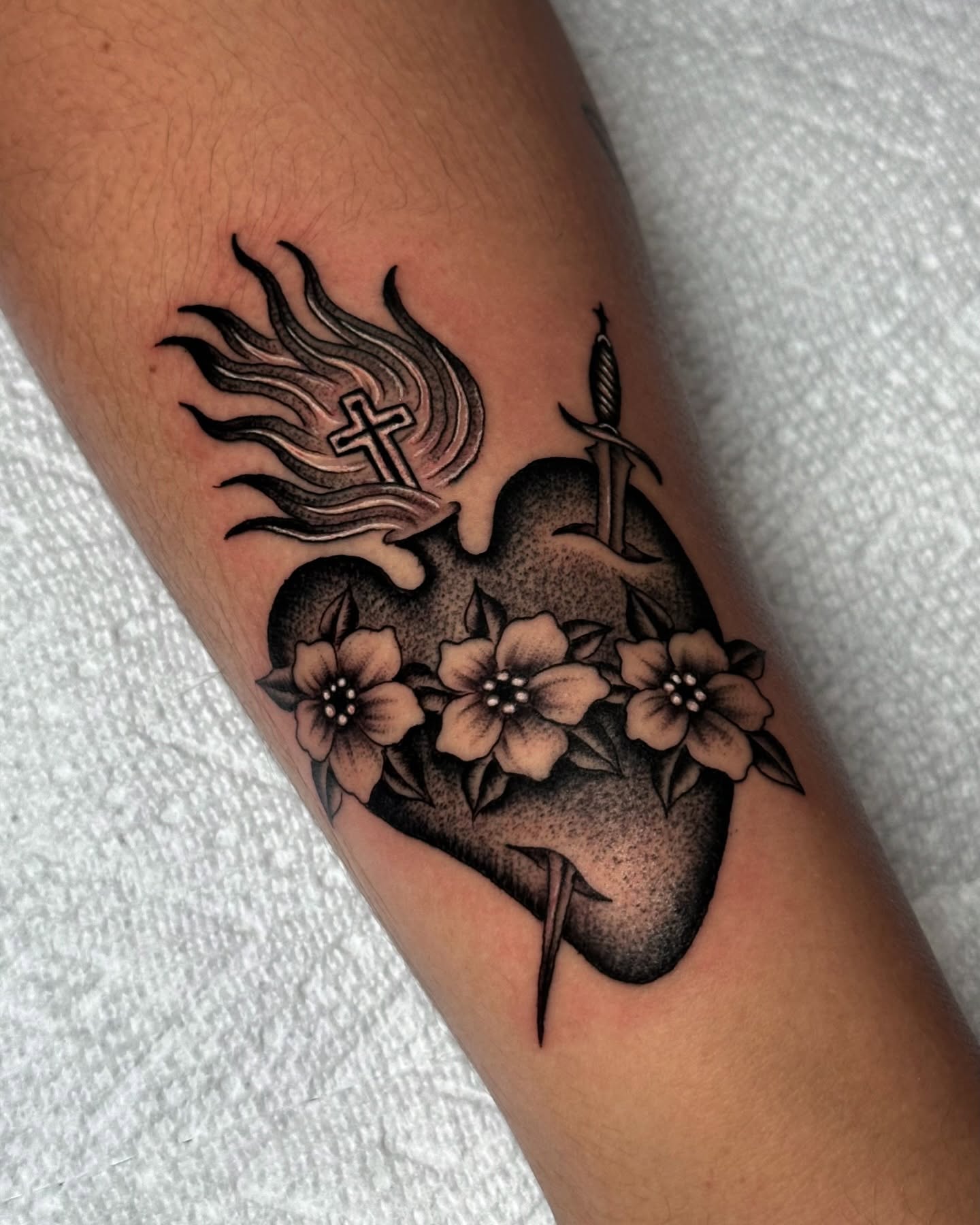 Heart with cross and flowers black and grey tattoo on the forearm by Matthew, Georgetown, Texas