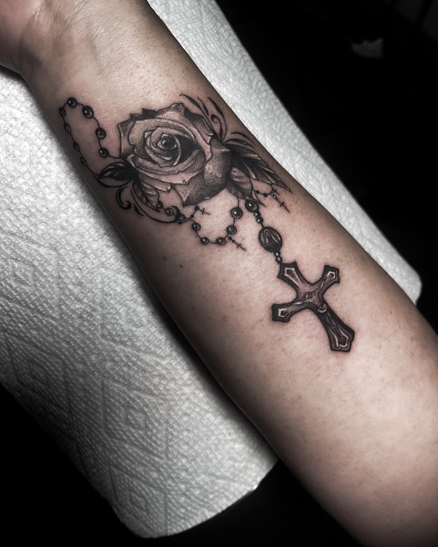Roses and cross realism tattoo on the forearm by Ema Fish
