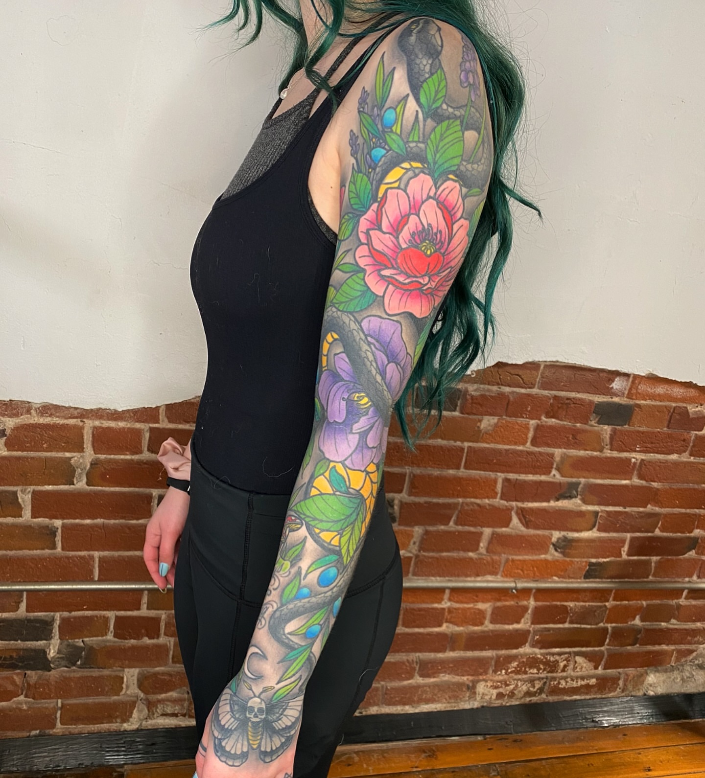 Snake and peony American traditional tattoo on the upper arm by kenneth nash
