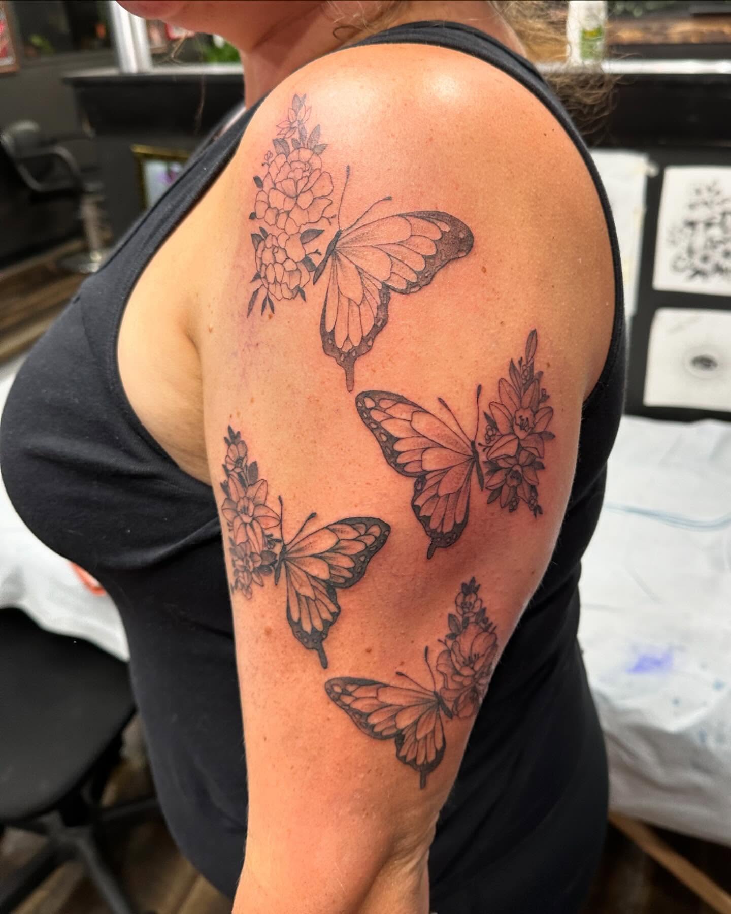 Butterflies and flowers black and grey tattoo on the shoulder by Emmy