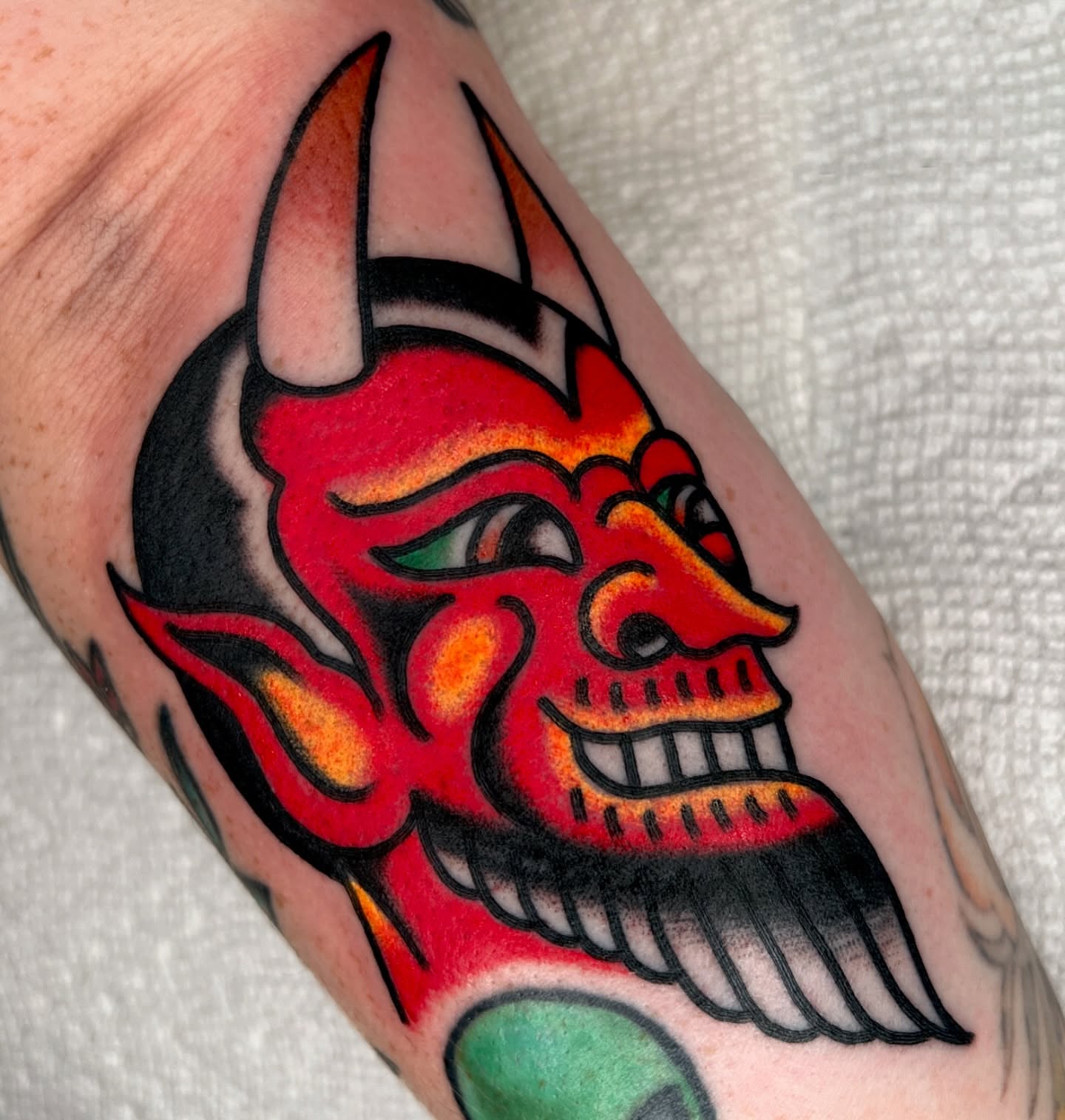 Demon head American traditional tattoo on the forearm by Ian Jett