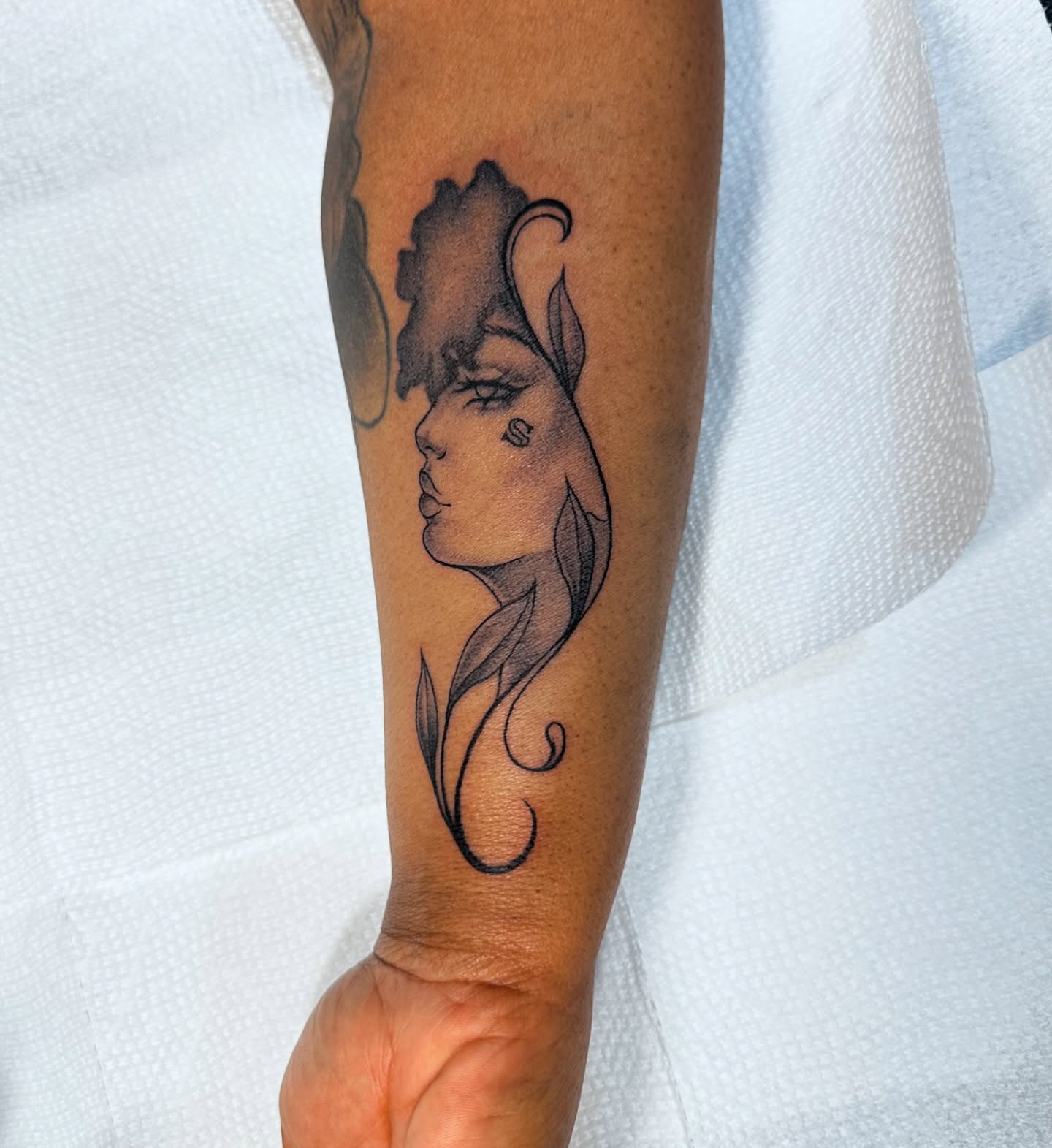 Woman's profile black and grey tattoo on the forearm by Mia Layne 🤎