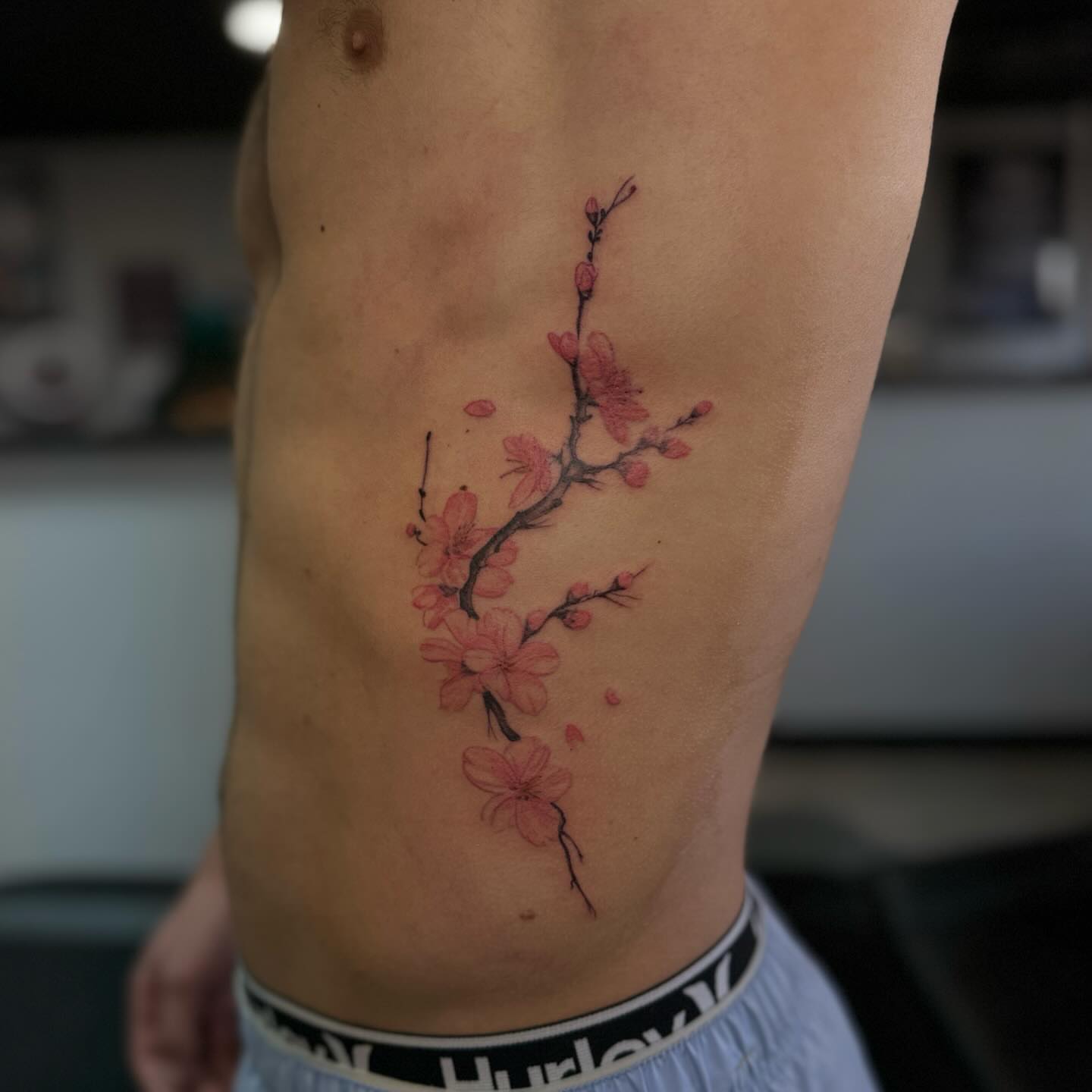 Cherry blossom branch dotwork tattoo on the ribs by Alexa Camacho