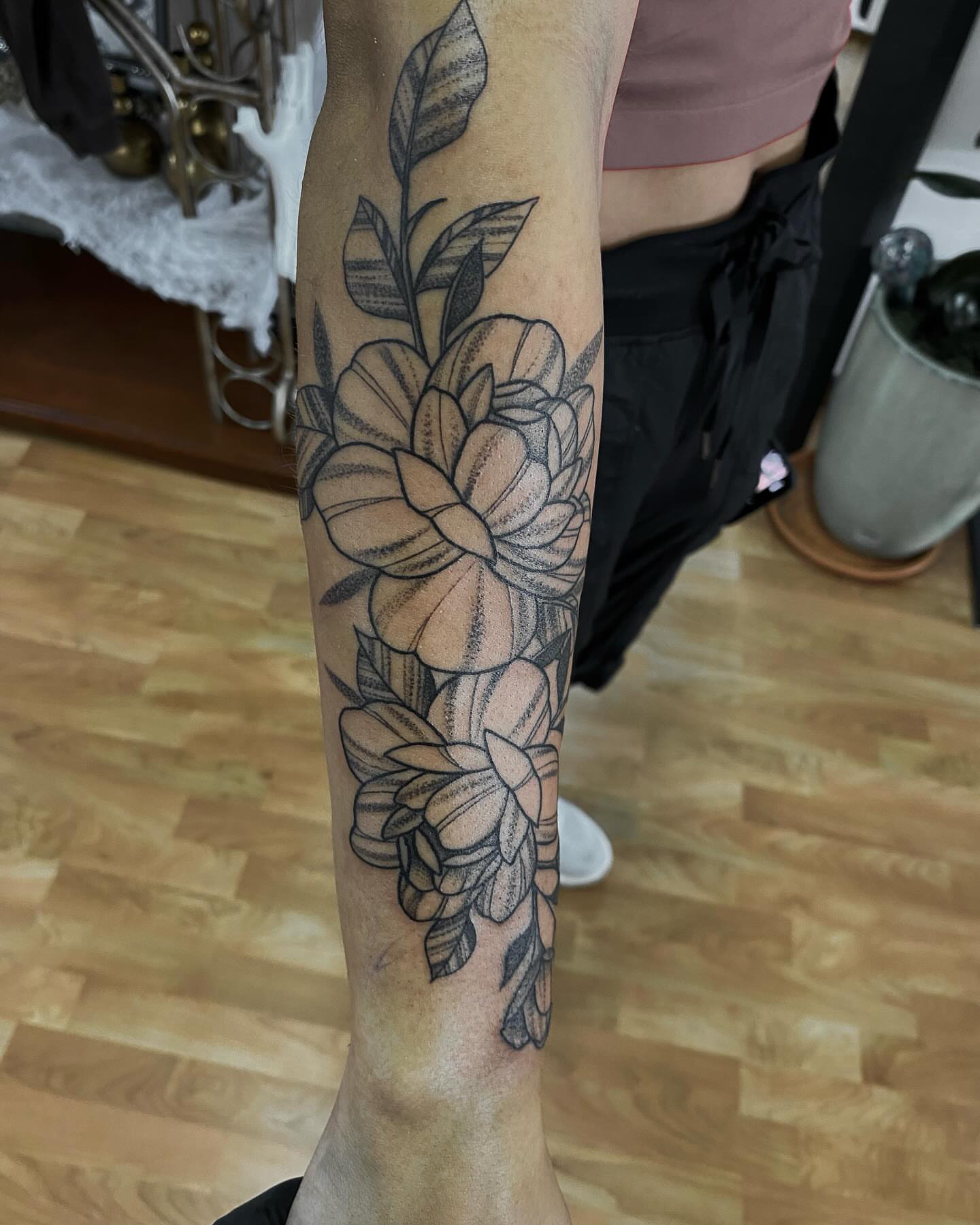 Floral arrangement black and grey tattoo on the forearm by Taya Lynn, Hudson, Wisconsin
