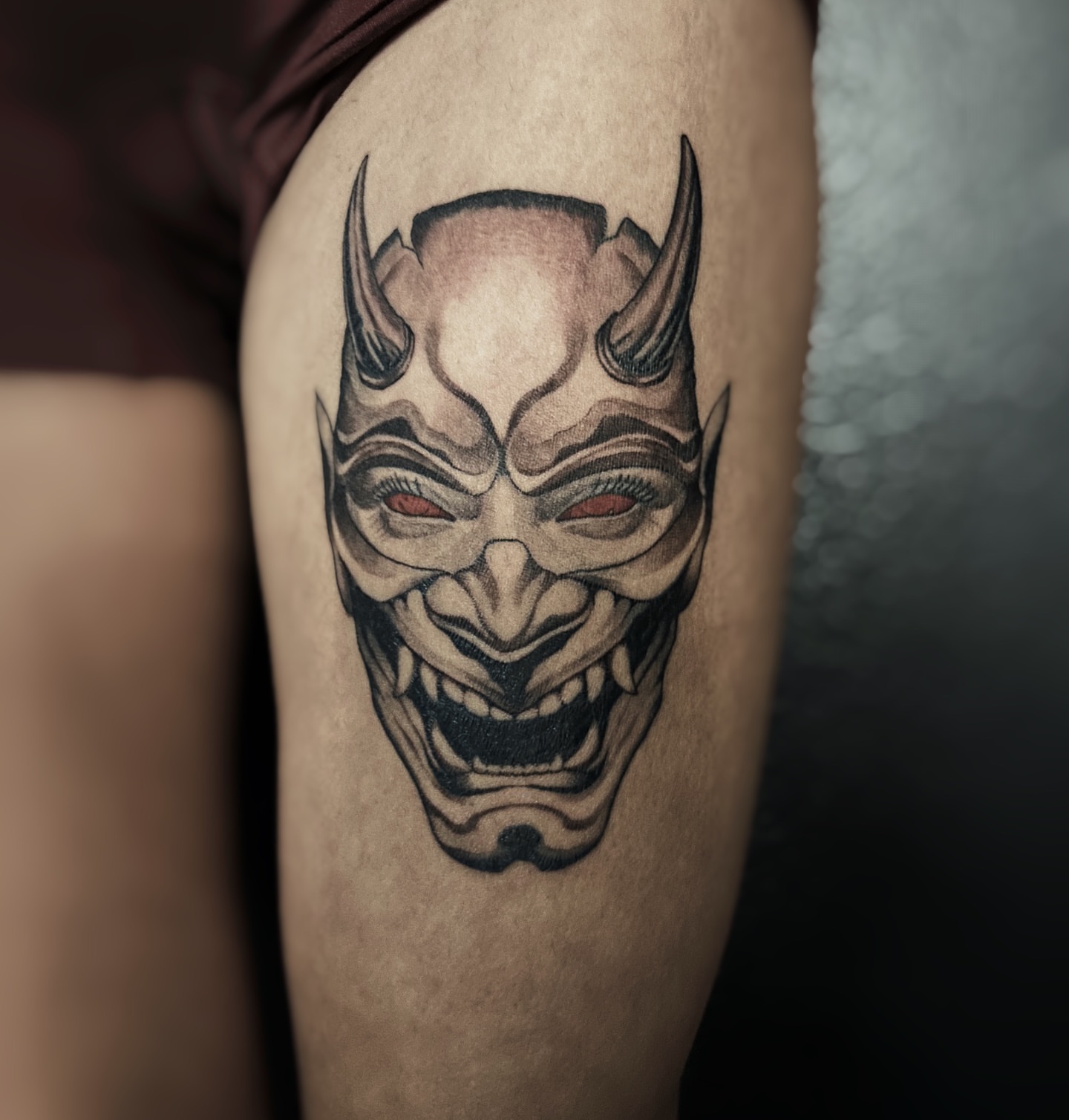 Demon mask black and grey tattoo on the forearm by Kolby