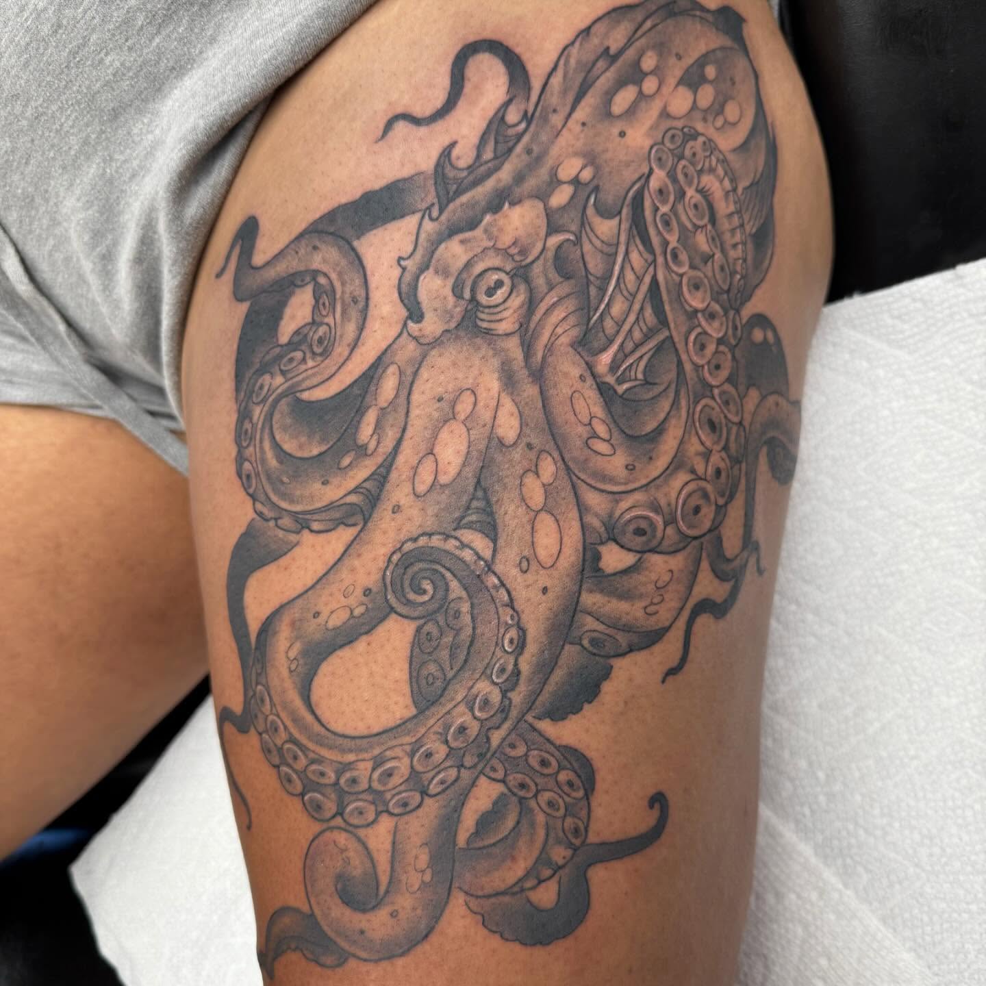 Octopus black and grey tattoo on the thigh by Brad Sterling