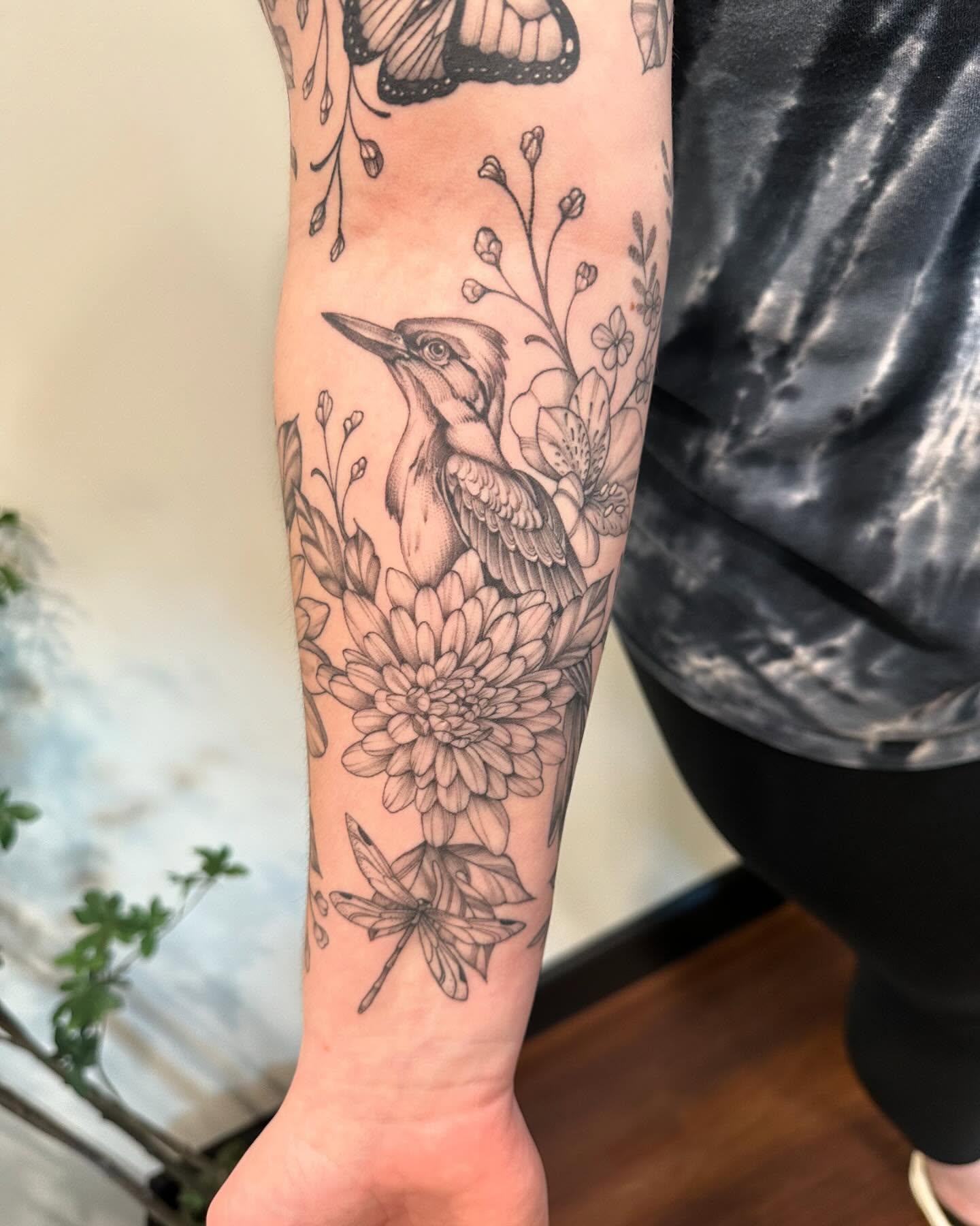 Bird and flowers realism tattoo on the forearm by Kate Darling